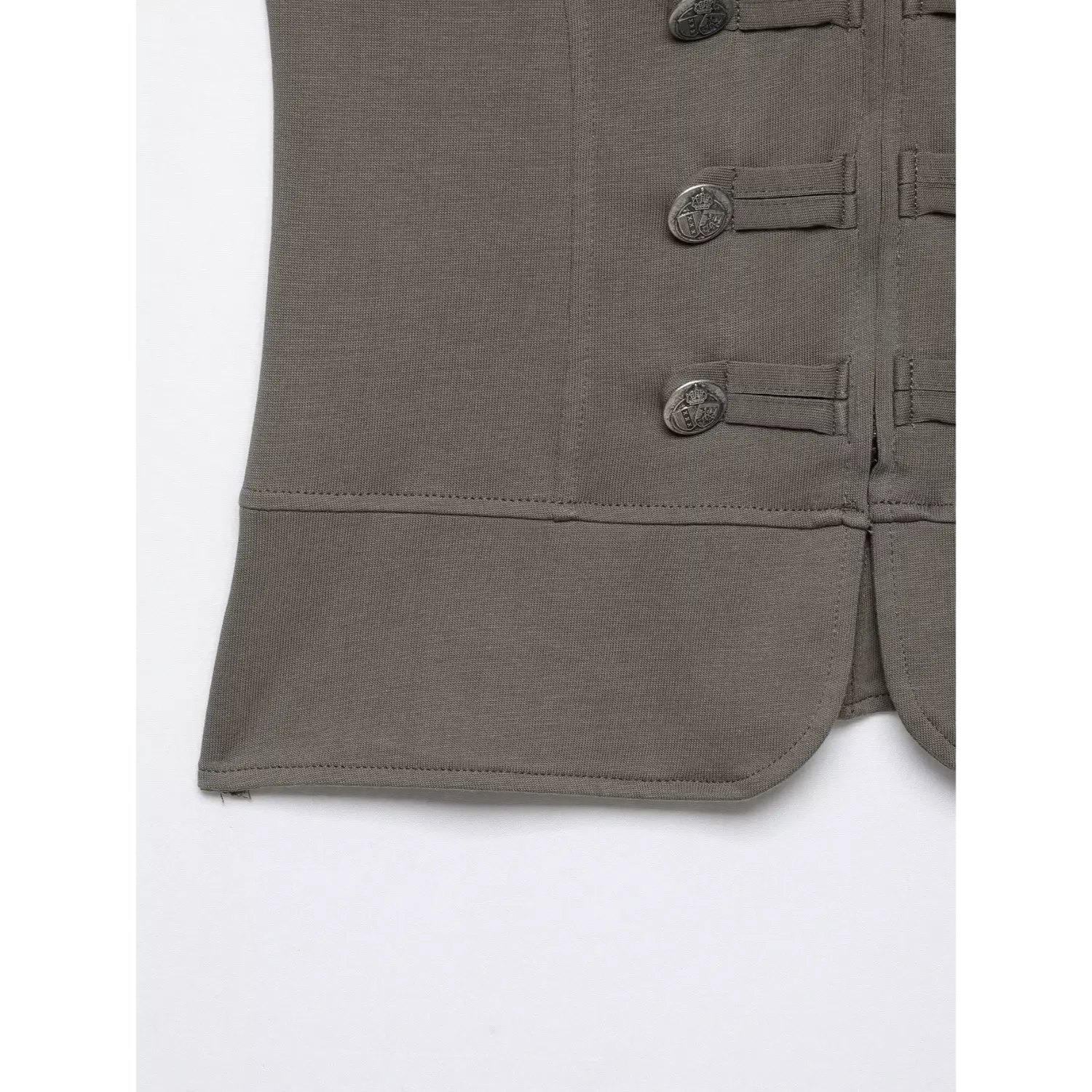 Close‑up hem detail grey fitted military top, curved peplum hem, stitching detail and decorative metal buttons