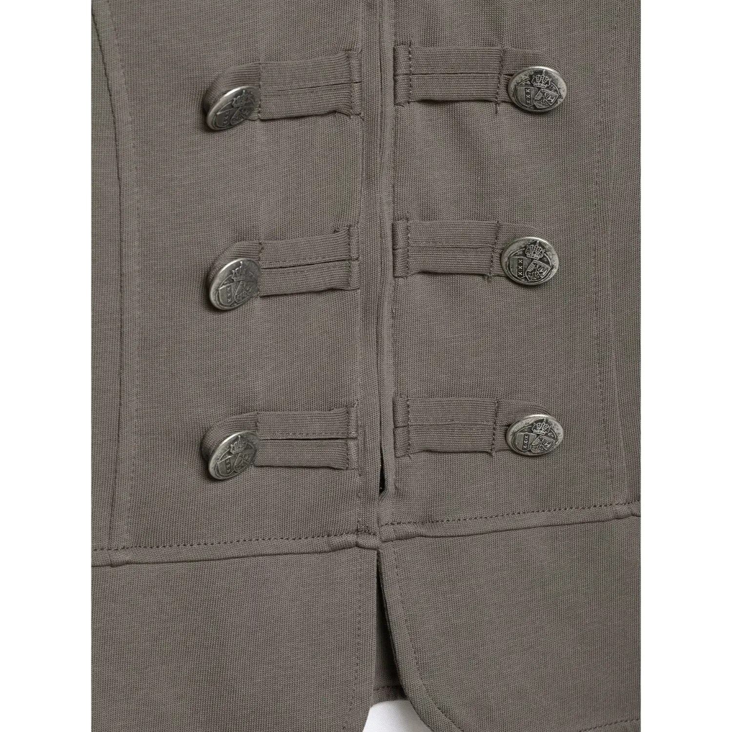 Close‑up lower front decorative metal crest buttons on grey fitted military knit top