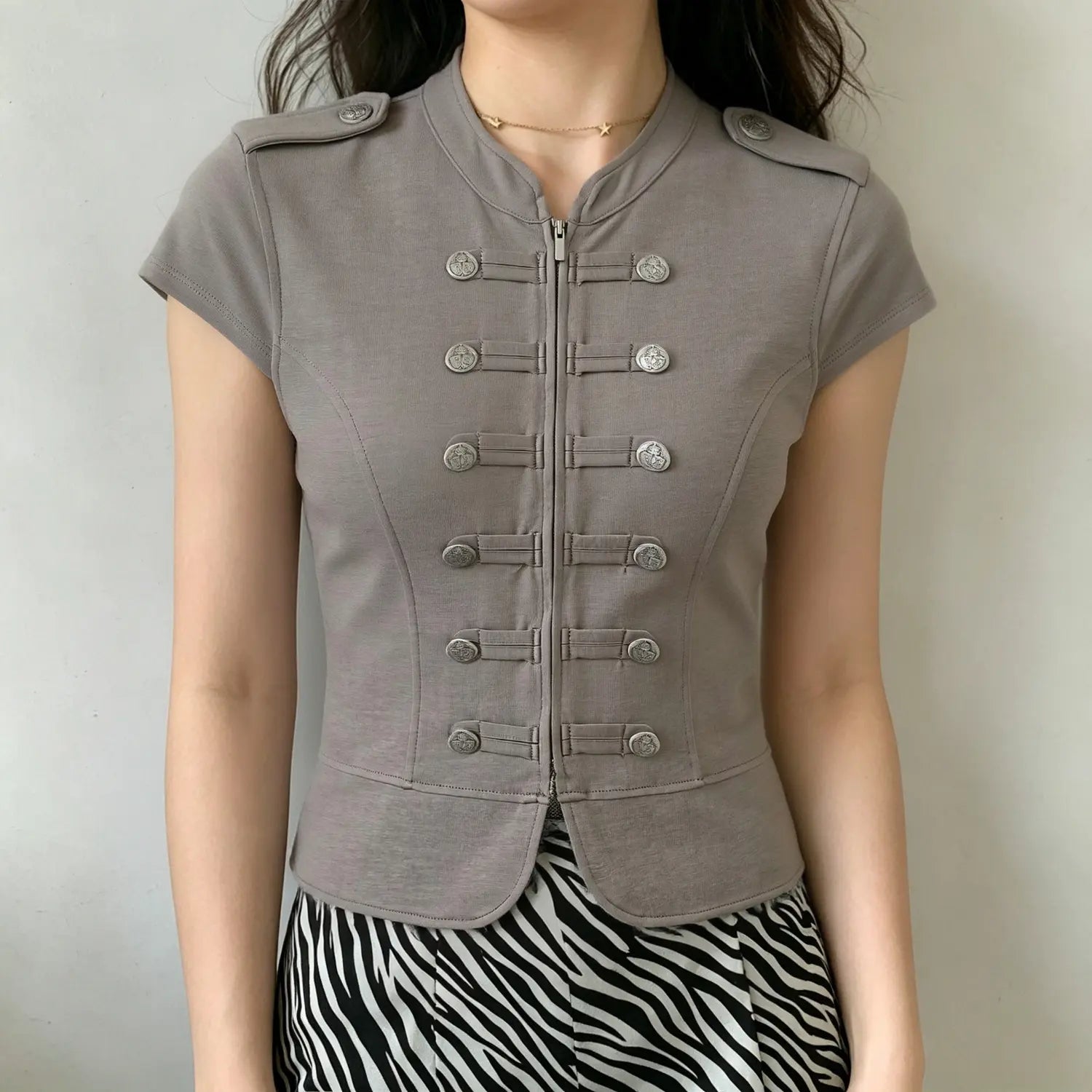 Model wearing grey fitted military‑inspired short sleeve top, full front view paired with zebra print bottom