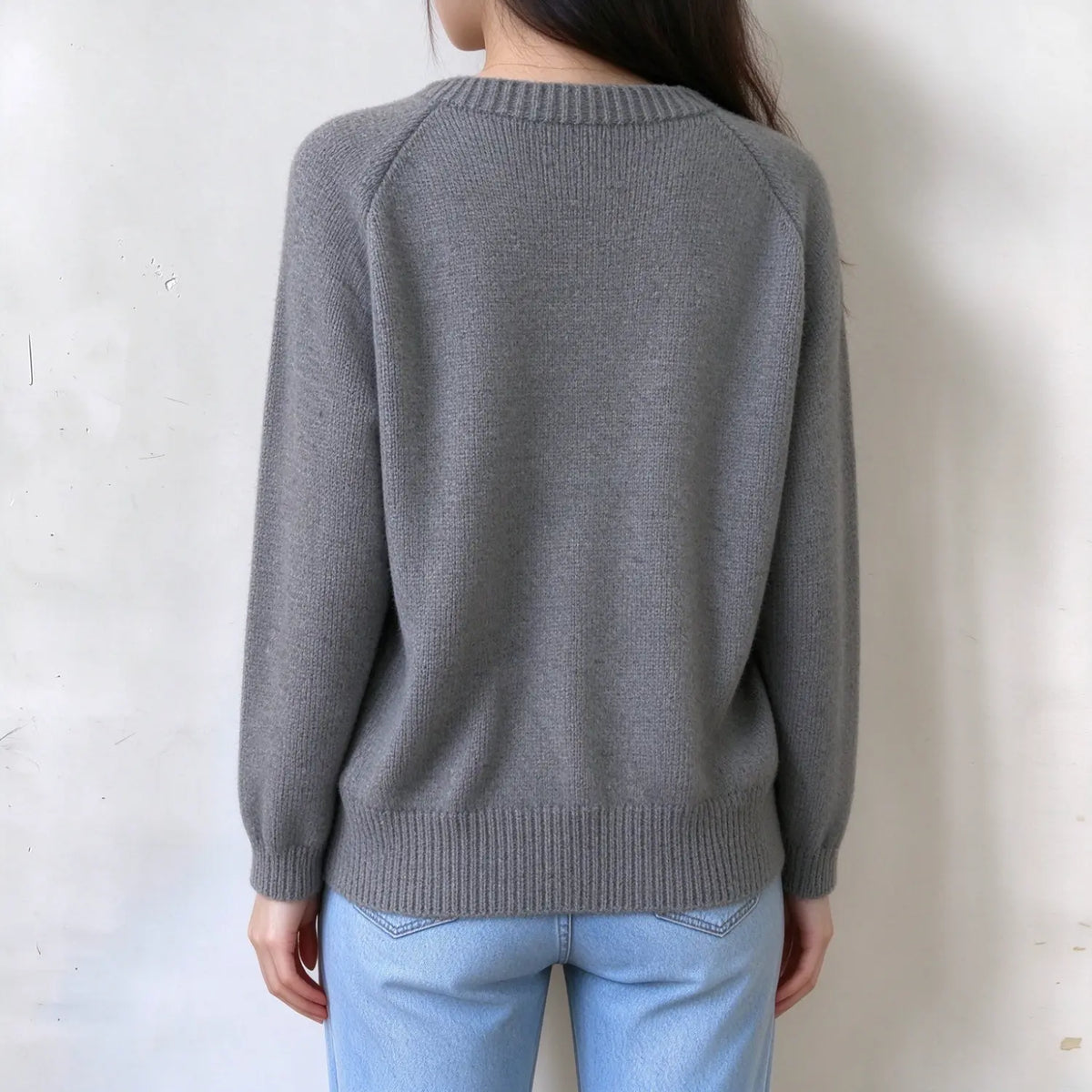 Female model back view, solid light grey raglan knit sweater, plain design, ribbed crew neck, hem and cuffs, loose long sleeves
