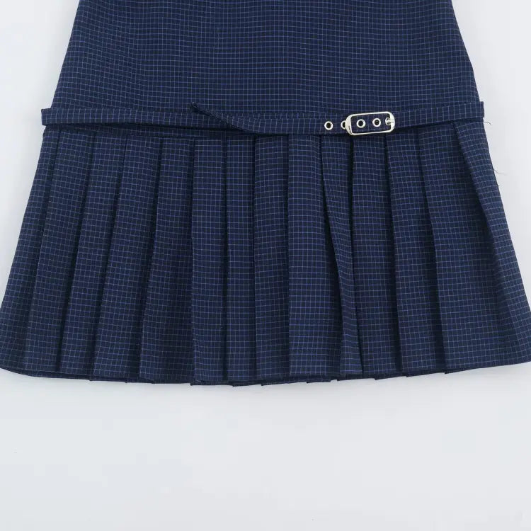 Close-up of pleated skirt and belt buckle