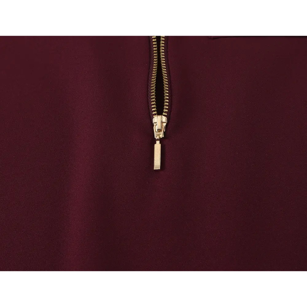 Close-up of gold zipper pull and teeth