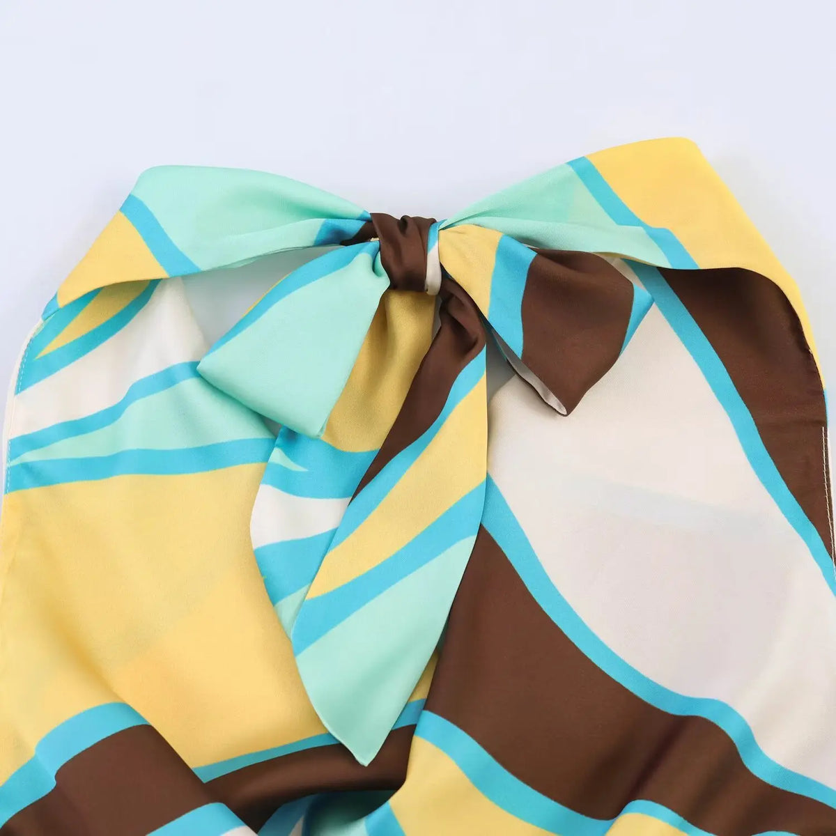 Full view of halter back bow tie, colorful abstract geometric print satin fabric