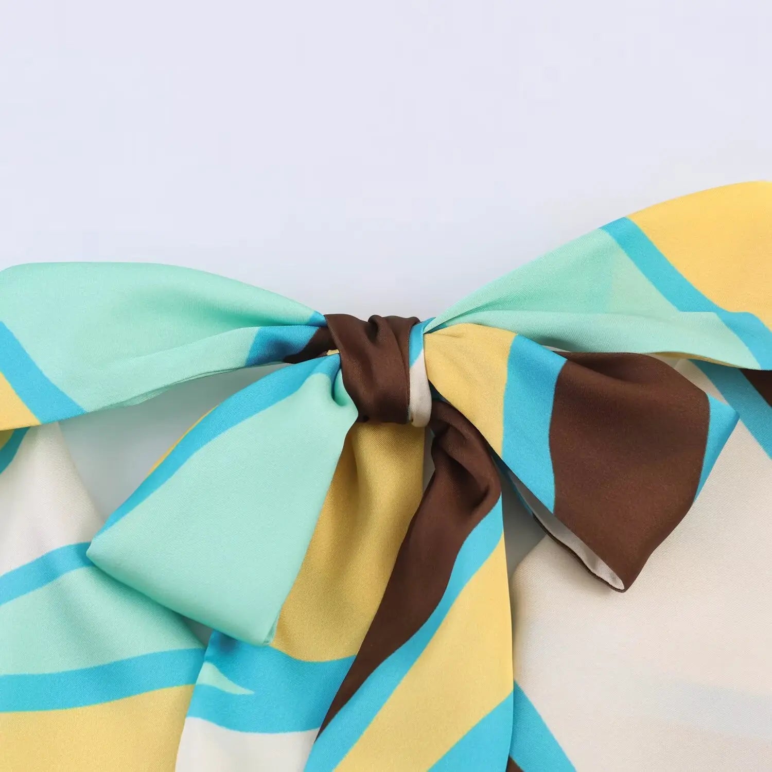 Close‑up of halter neck back knot, abstract printed satin bow detail