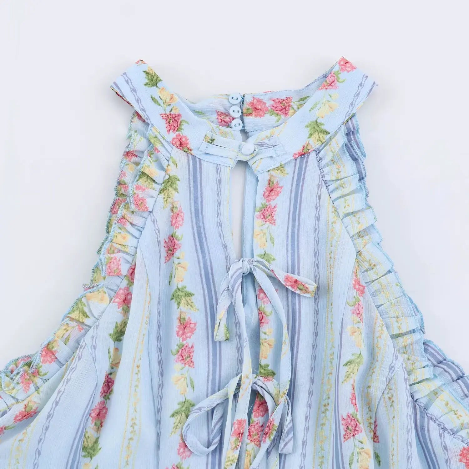 Back neck close-up, hollow cutout with matching fabric self tie bow, three small decorative buttons on collar