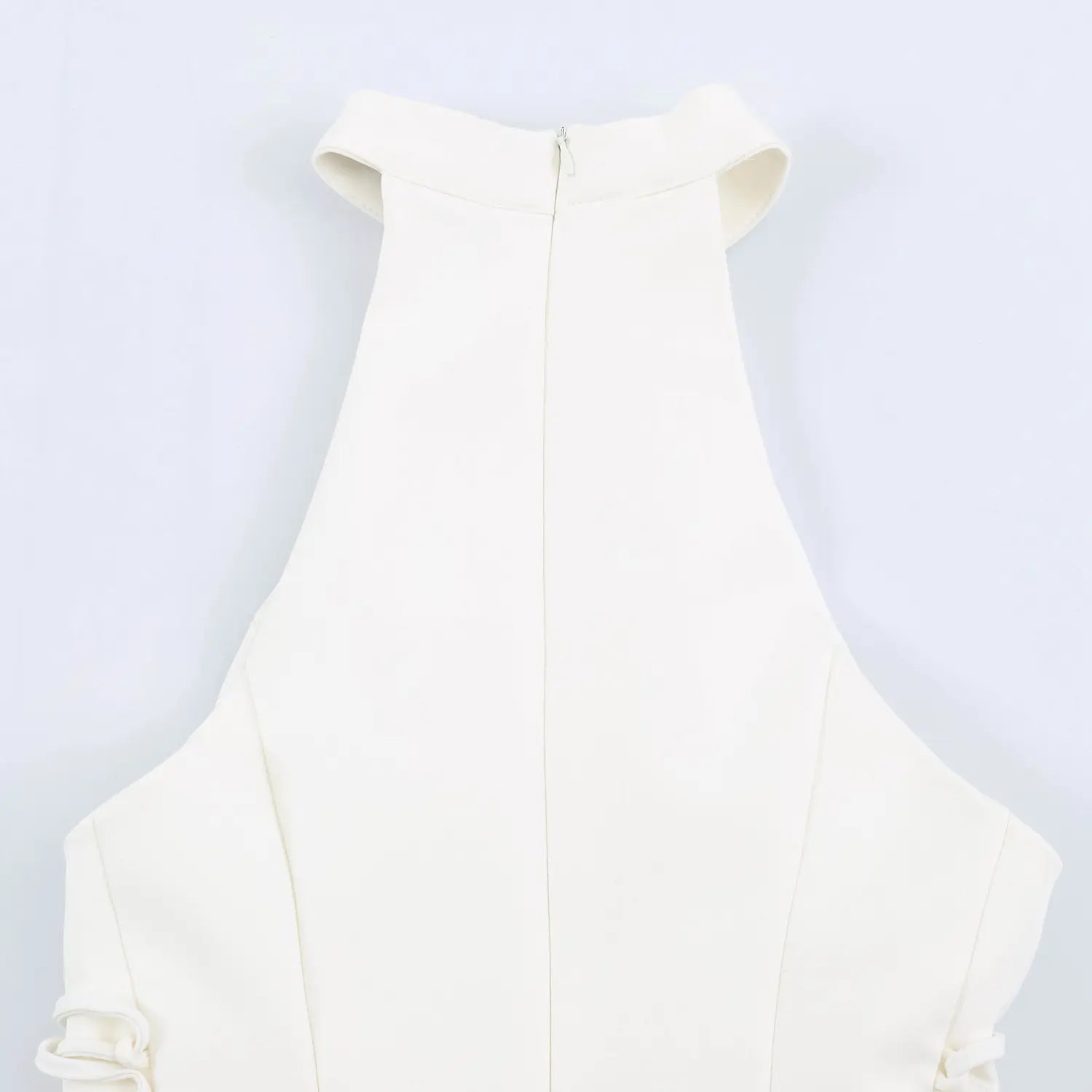 Rear close-up of halter neck and center back zipper on white mini dress