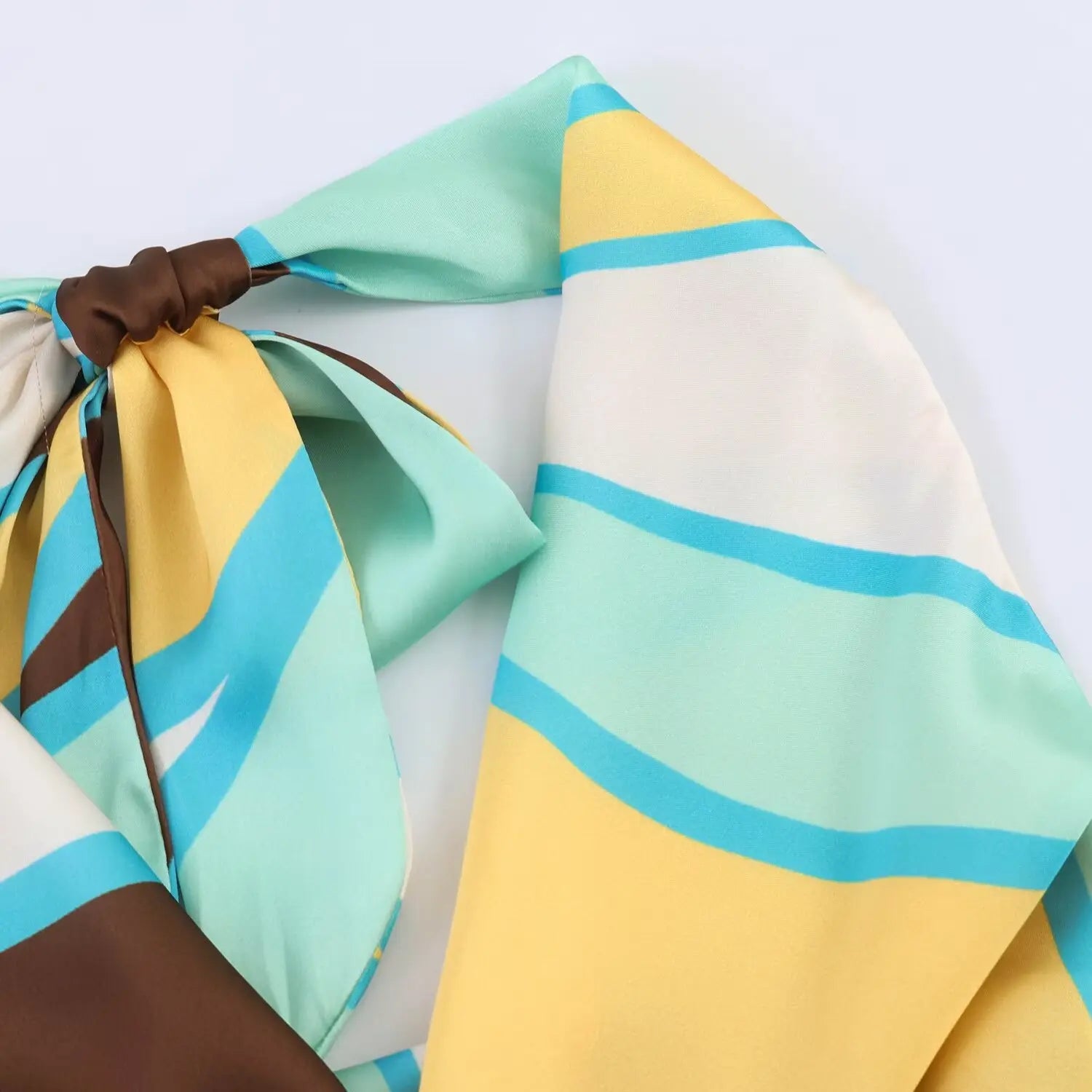Close‑up view of halter back knot, abstract printed satin fabric texture