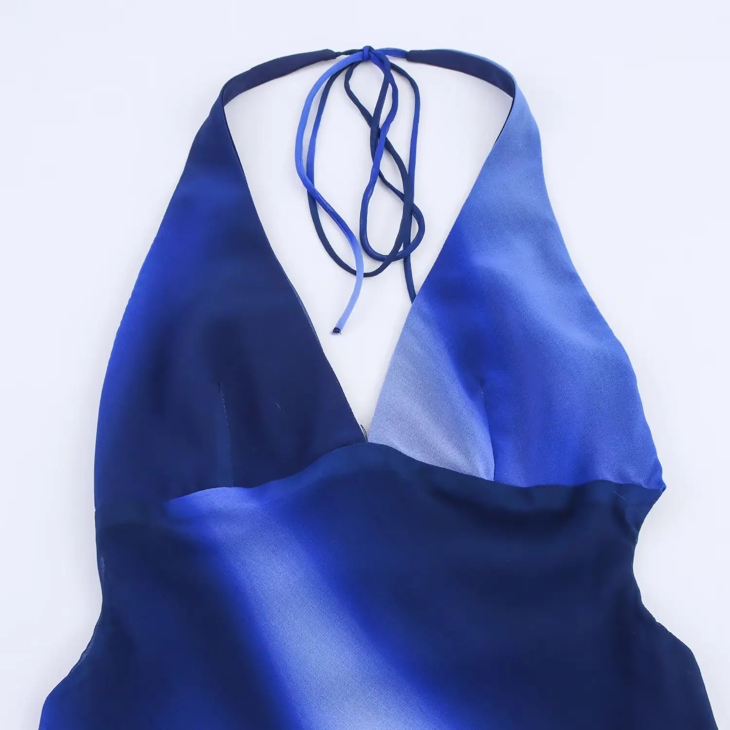Close‑up of halter neckline, deep v plunge, adjustable tie‑back straps, blue gradient chiffon fabric texture