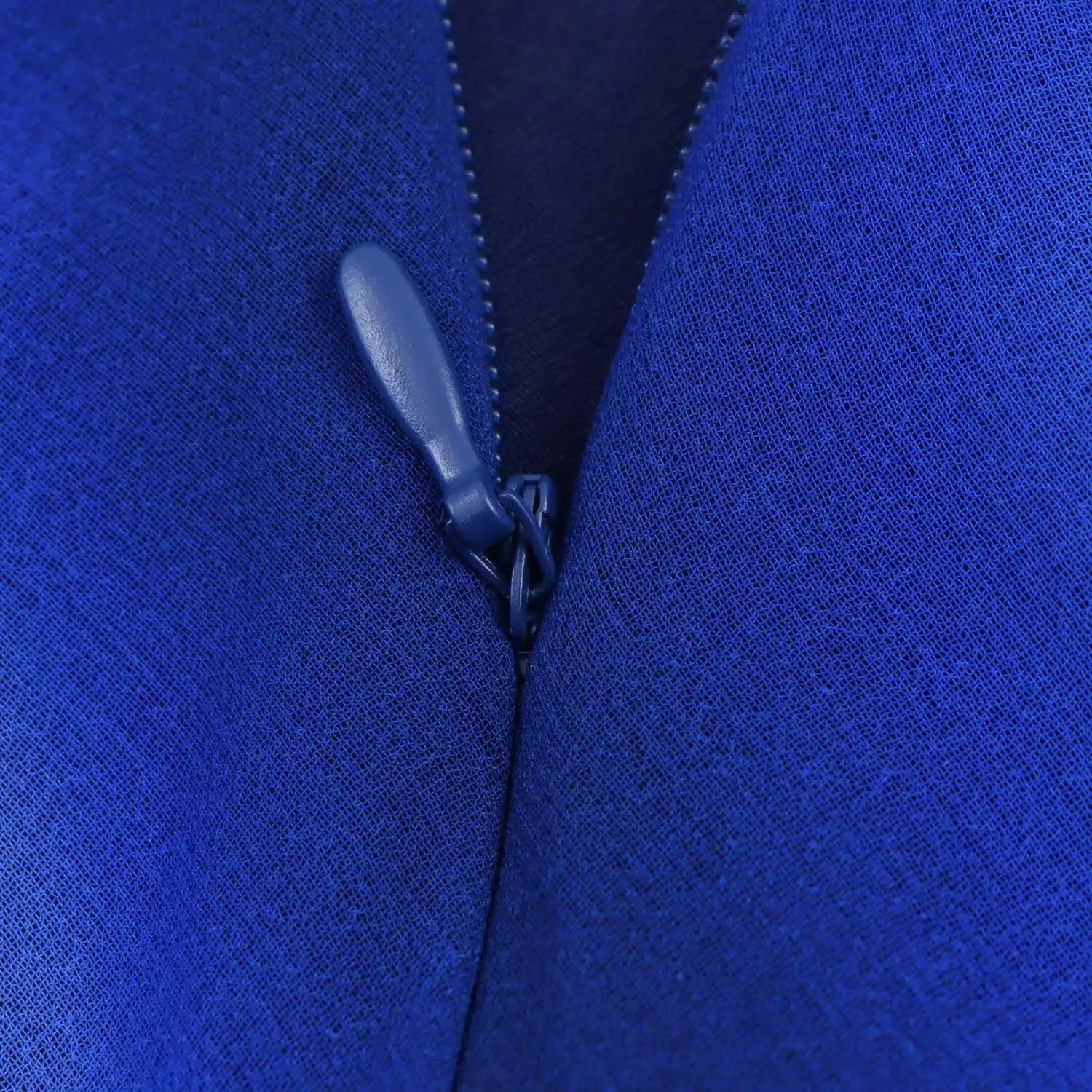 Macro close‑up of invisible side zipper, blue matching zipper pull, chiffon dress side seam hardware detail