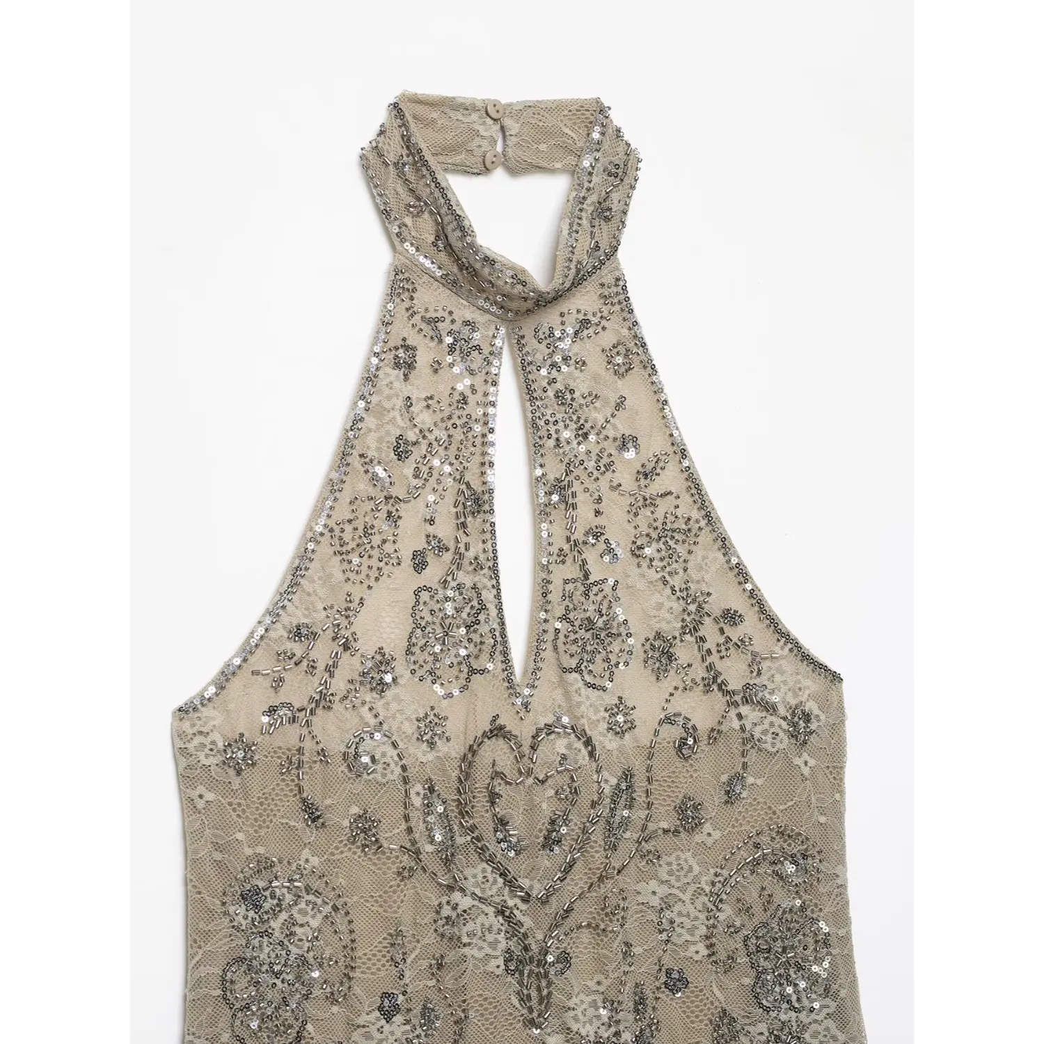 Upper torso close‑up of halter neckline, keyhole cutout and ornate floral silver beading on beige lace fabric
