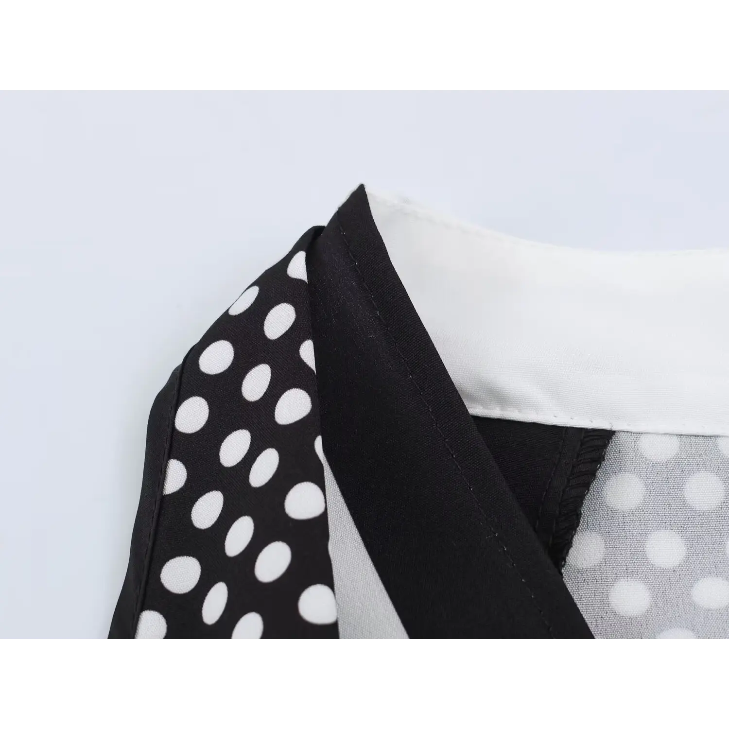 Halter shoulder partial shot, contrast black piping along armhole edge, neat serged stitching