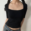 Lifestyle shot of model wearing the black halter square-neck mid-sleeve fitted top