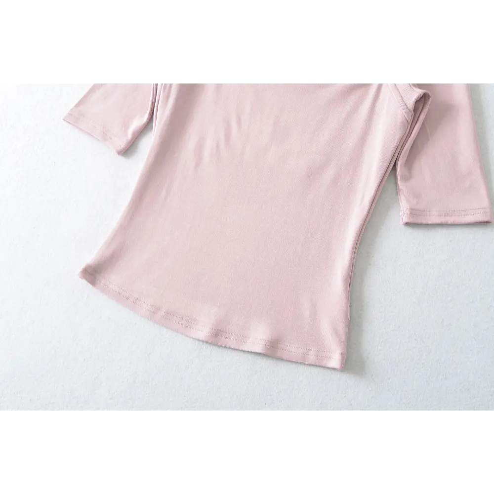Close-up of the fabric texture and hem stitching on the pink halter top