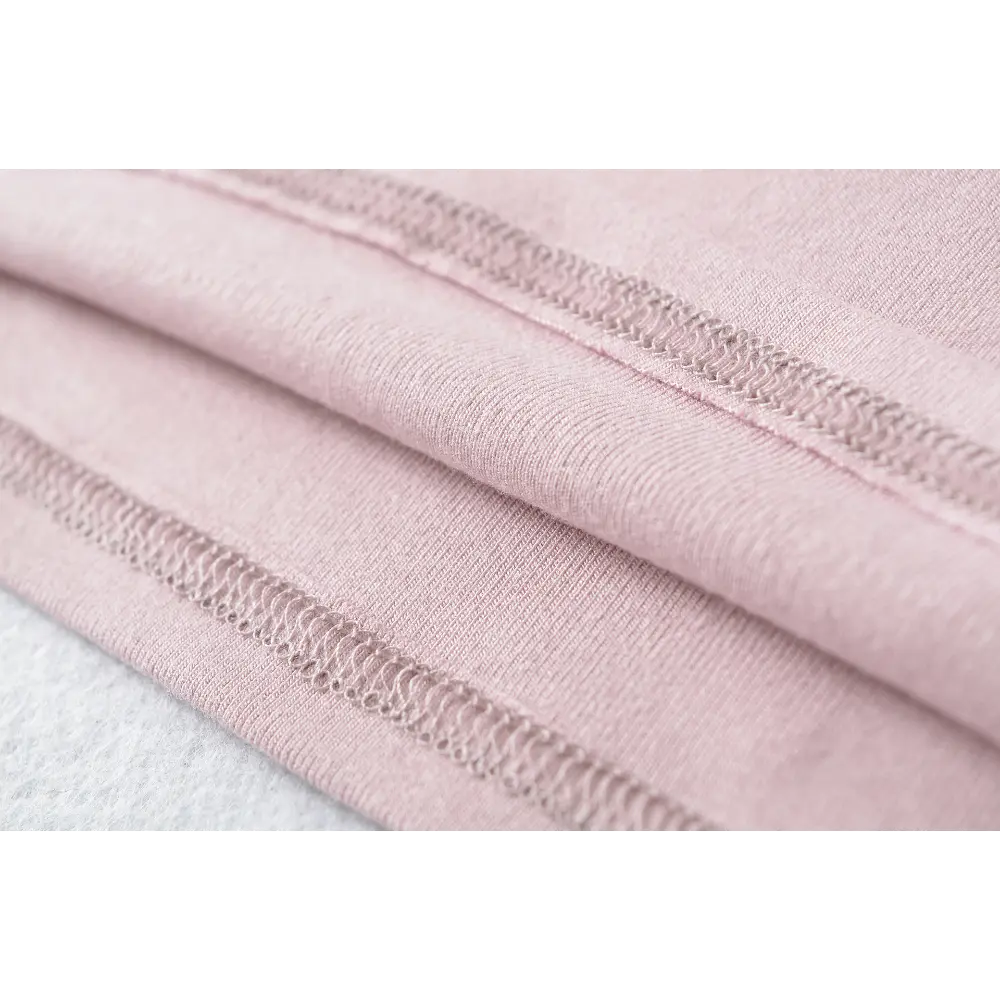 Close-up of the hem stitching on the pink halter square-neck top