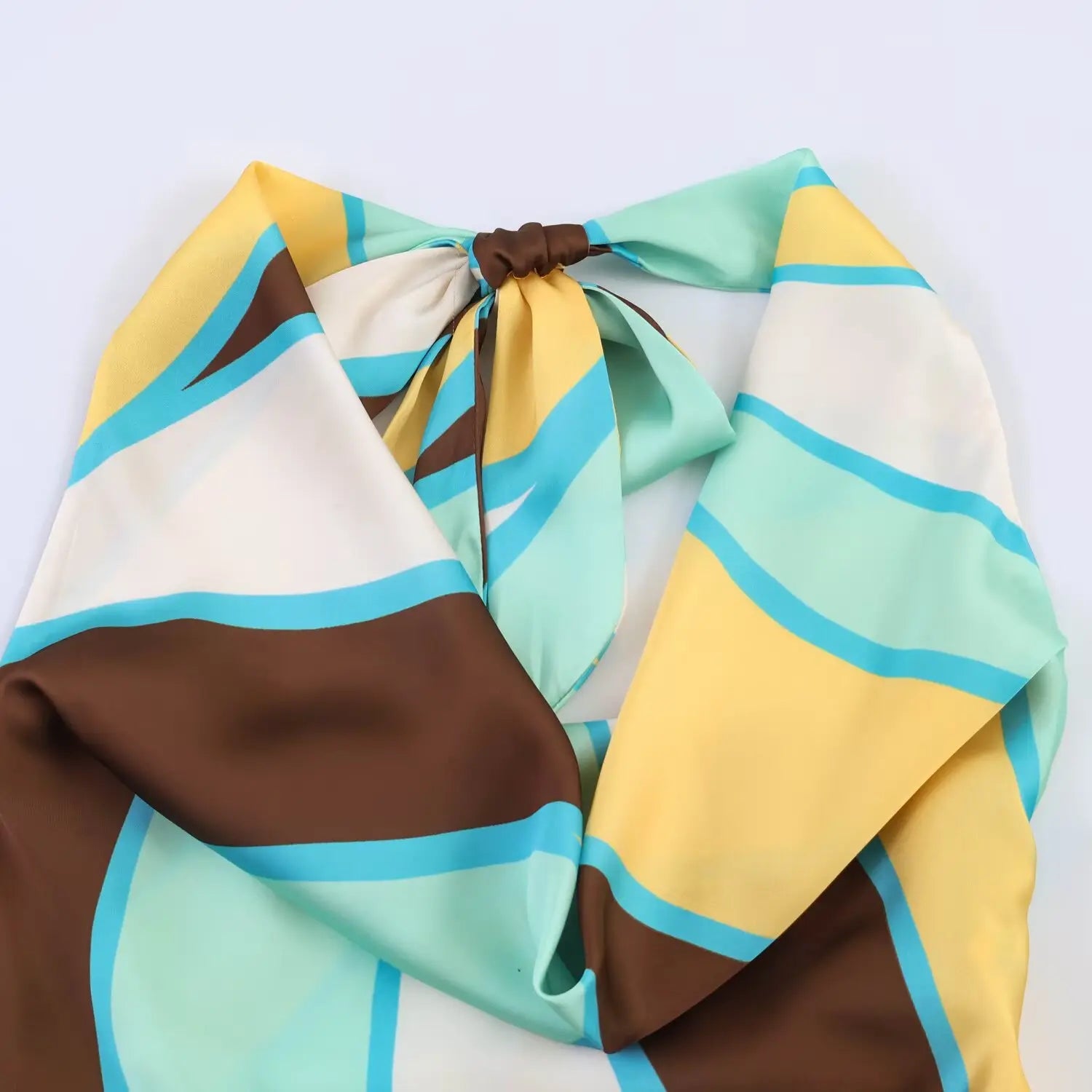 Close‑up of halter neck tie detail, colorful abstract geometric print fabric