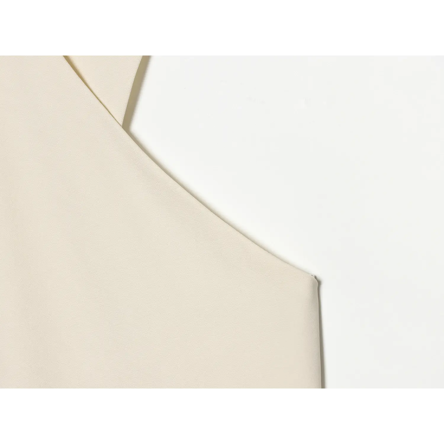 Close-up stitching detail of armhole on cream cross halter sleeveless blouse