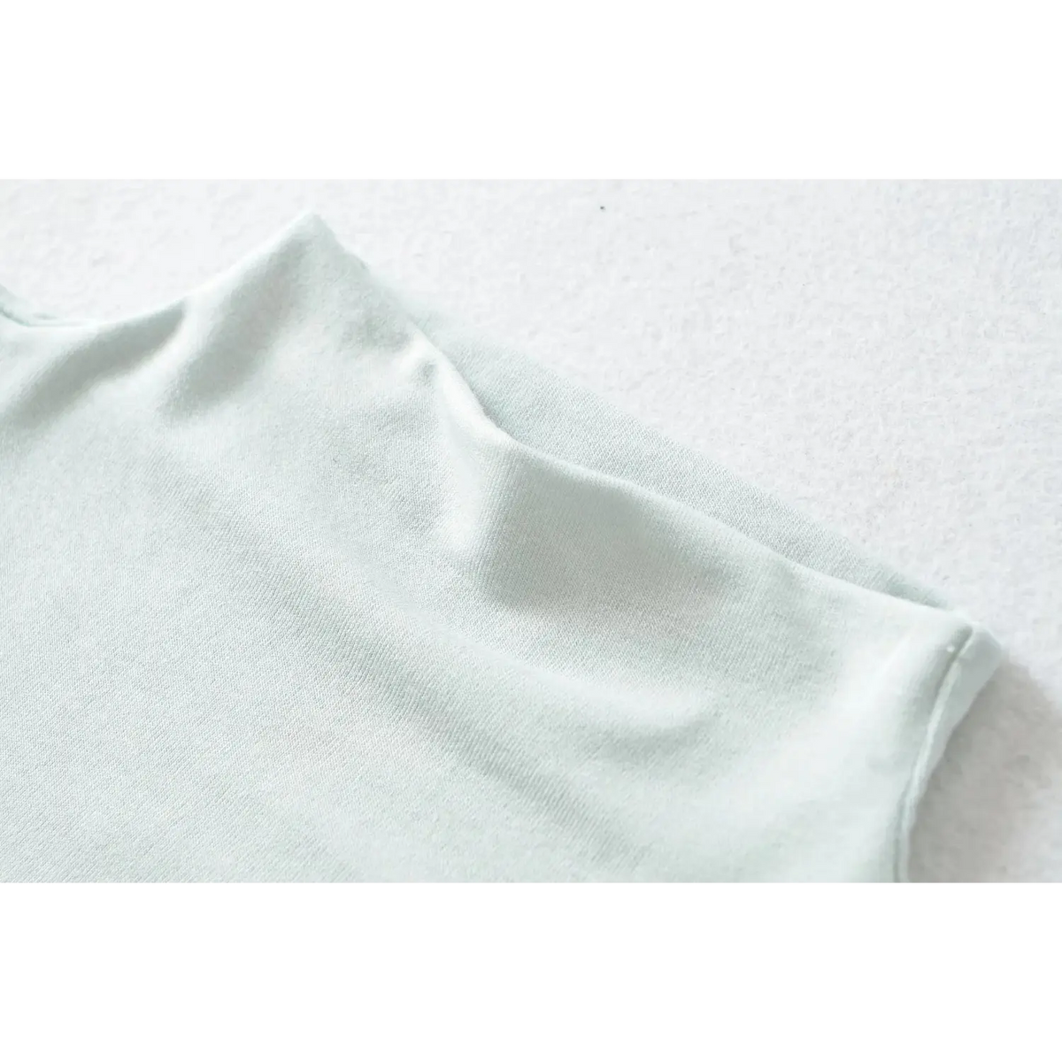 Macro closeup of haze blue stretch jersey fabric texture for high neck sleeveless dress