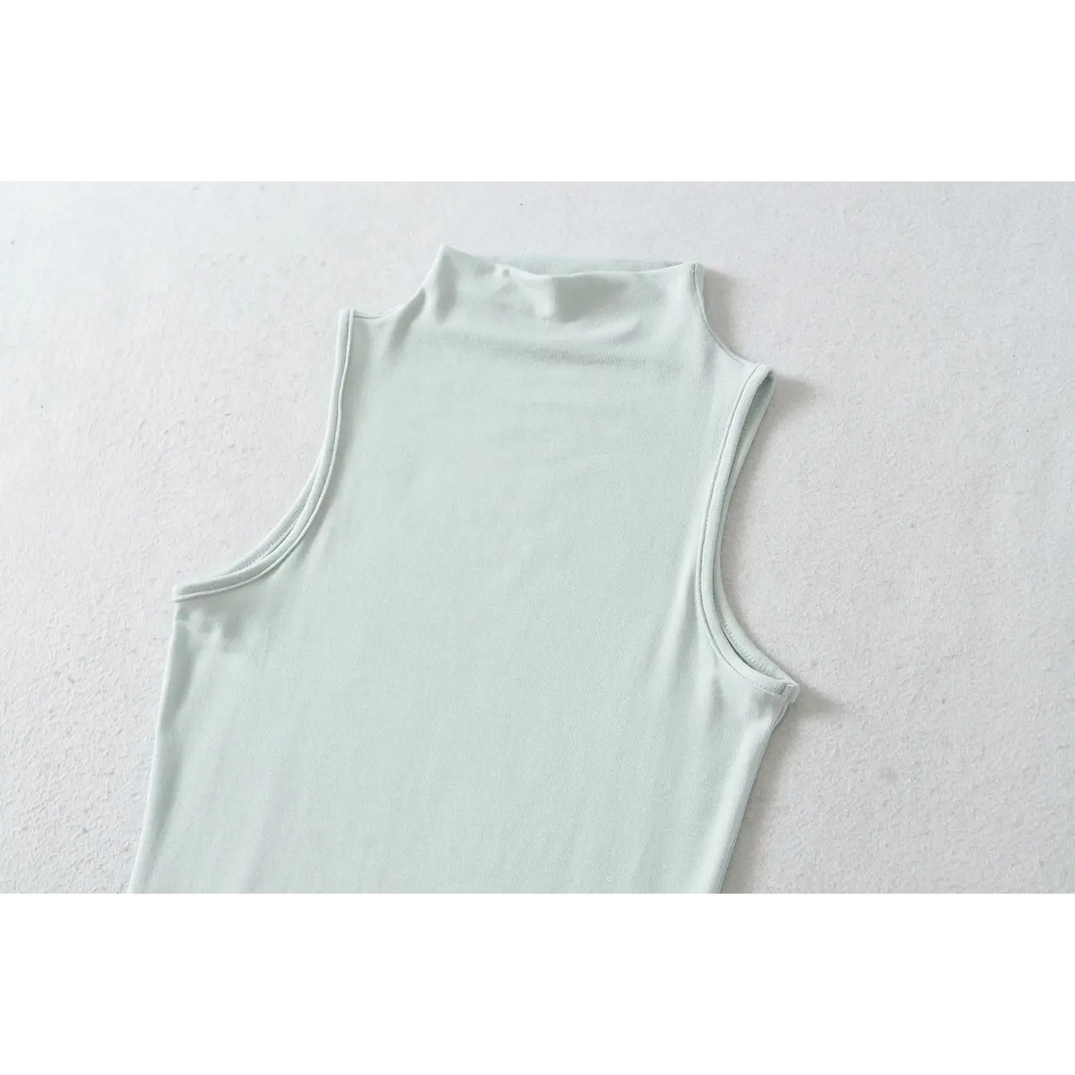 Close up detail of haze blue high neck sleeveless dress neckline and armhole
