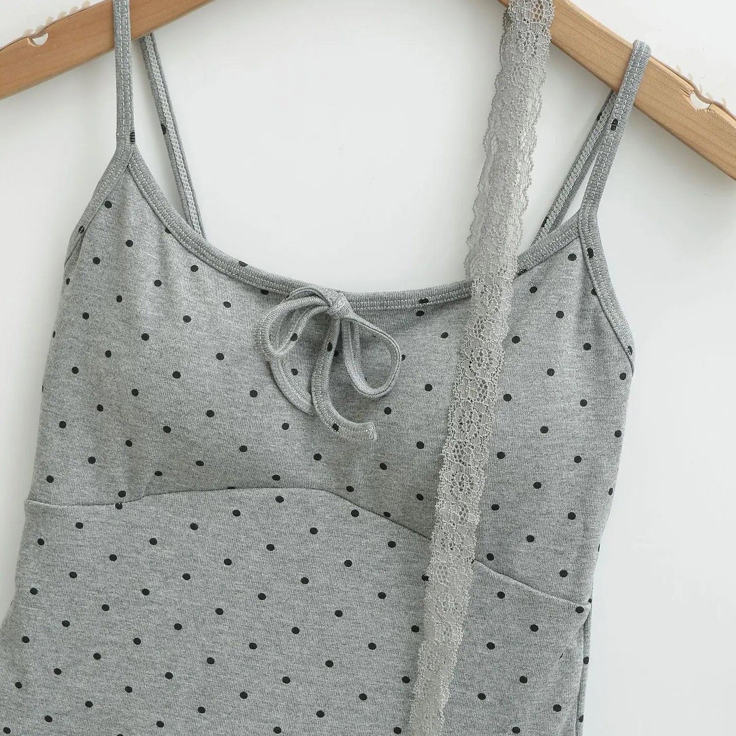 Heather gray black polka dot knit cami hanging on wooden hanger flat shot, bust tie bow matching lace choker thin printed straps knit fabric white background
