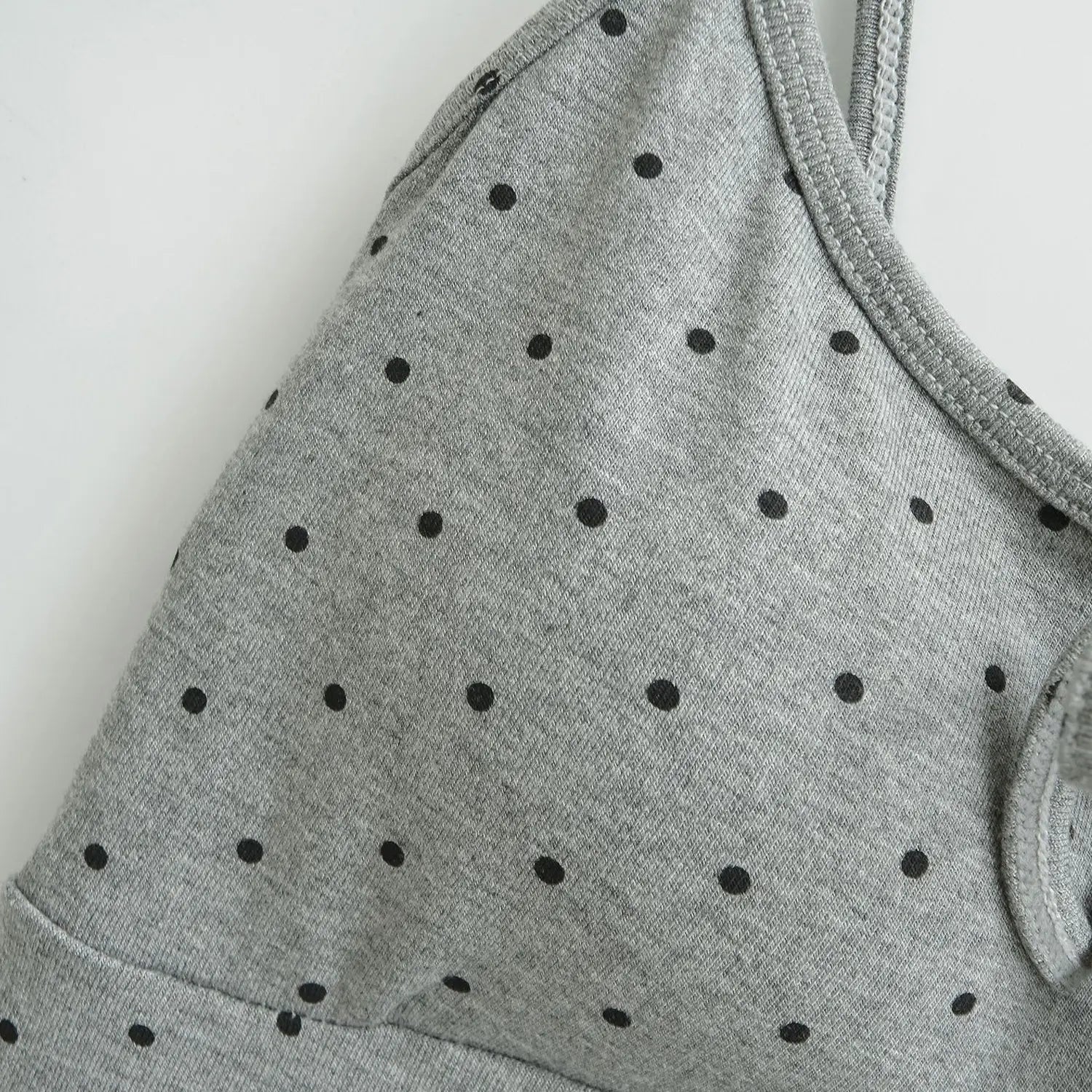 Heather gray black polka dot knit cami shoulder flat close-up, thin elastic straps dot printed mixed knit fabric stitching white background shot