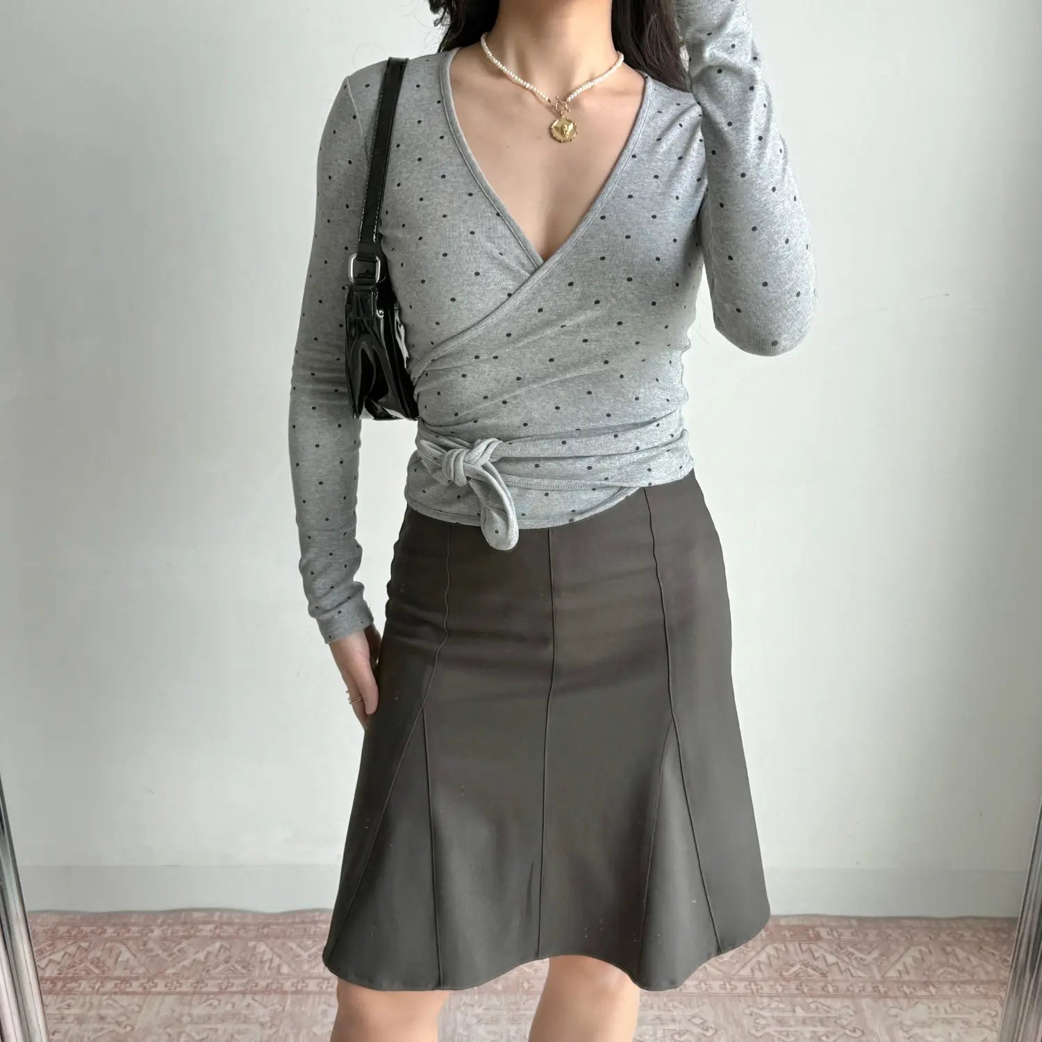 Full outfit model shot heather gray polka dot wrap long sleeve top paired with dark midi skirt