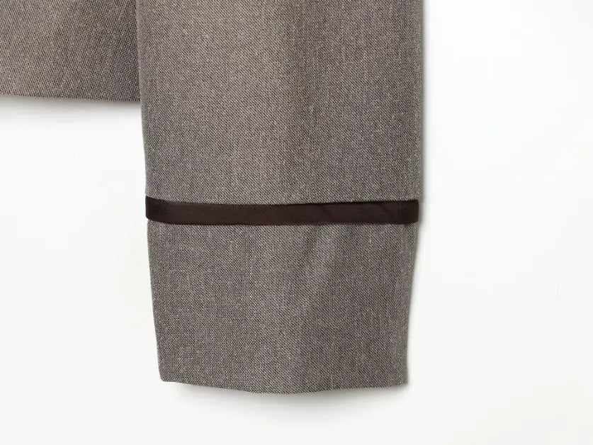 Close-up of sleeve cuff with dark brown contrast trim