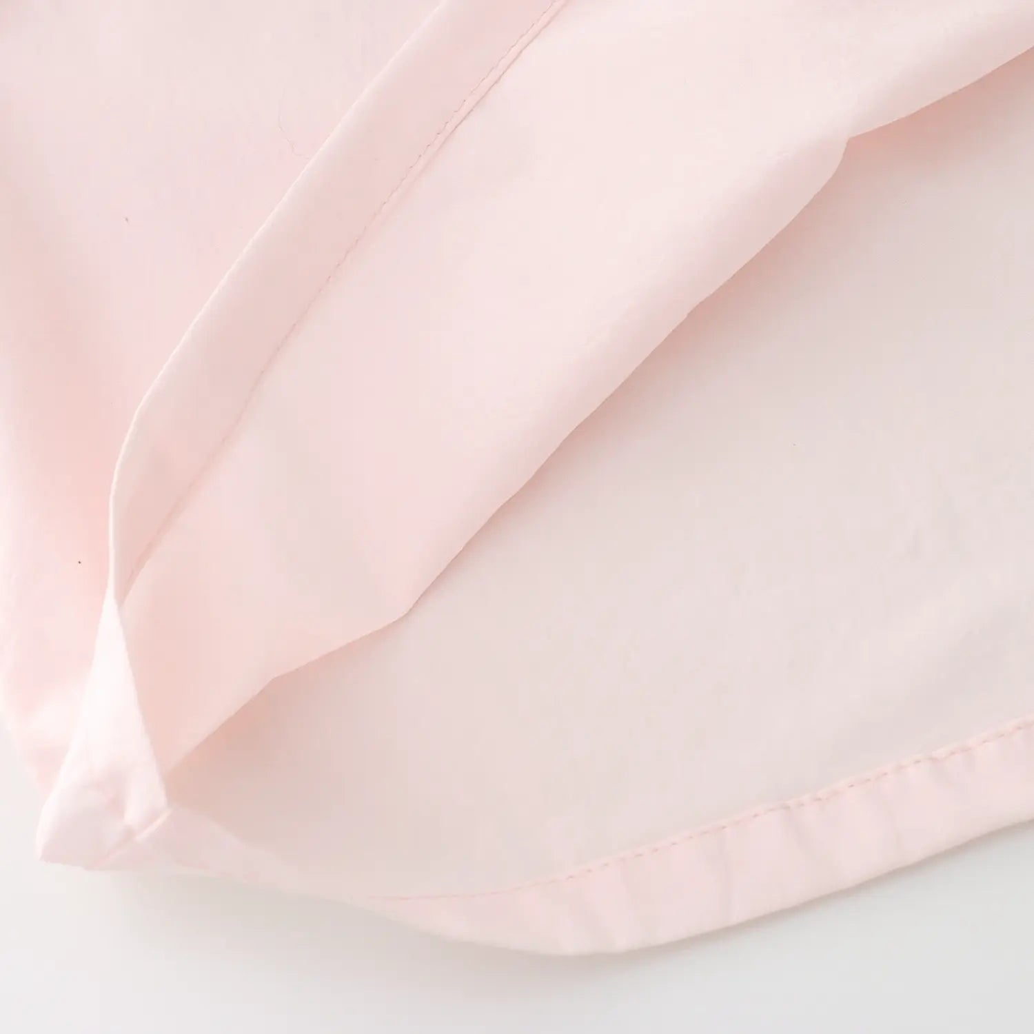 Hem folded double layer cotton texture macro close-up, lightweight breathable washed cotton double binding durable stitching soft drape fabric detail shot