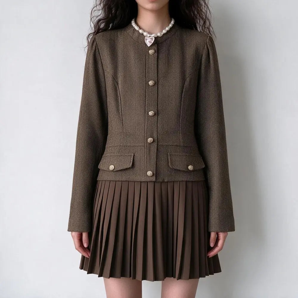 Model wearing herringbone gold button pleated mini dress, front view