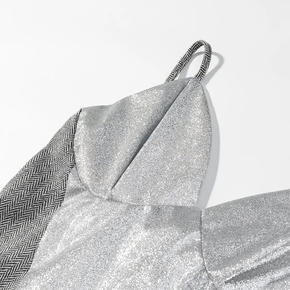 Close-up of the hem on the cami top, showing the curved scalloped edge, herringbone fabric, and white lining