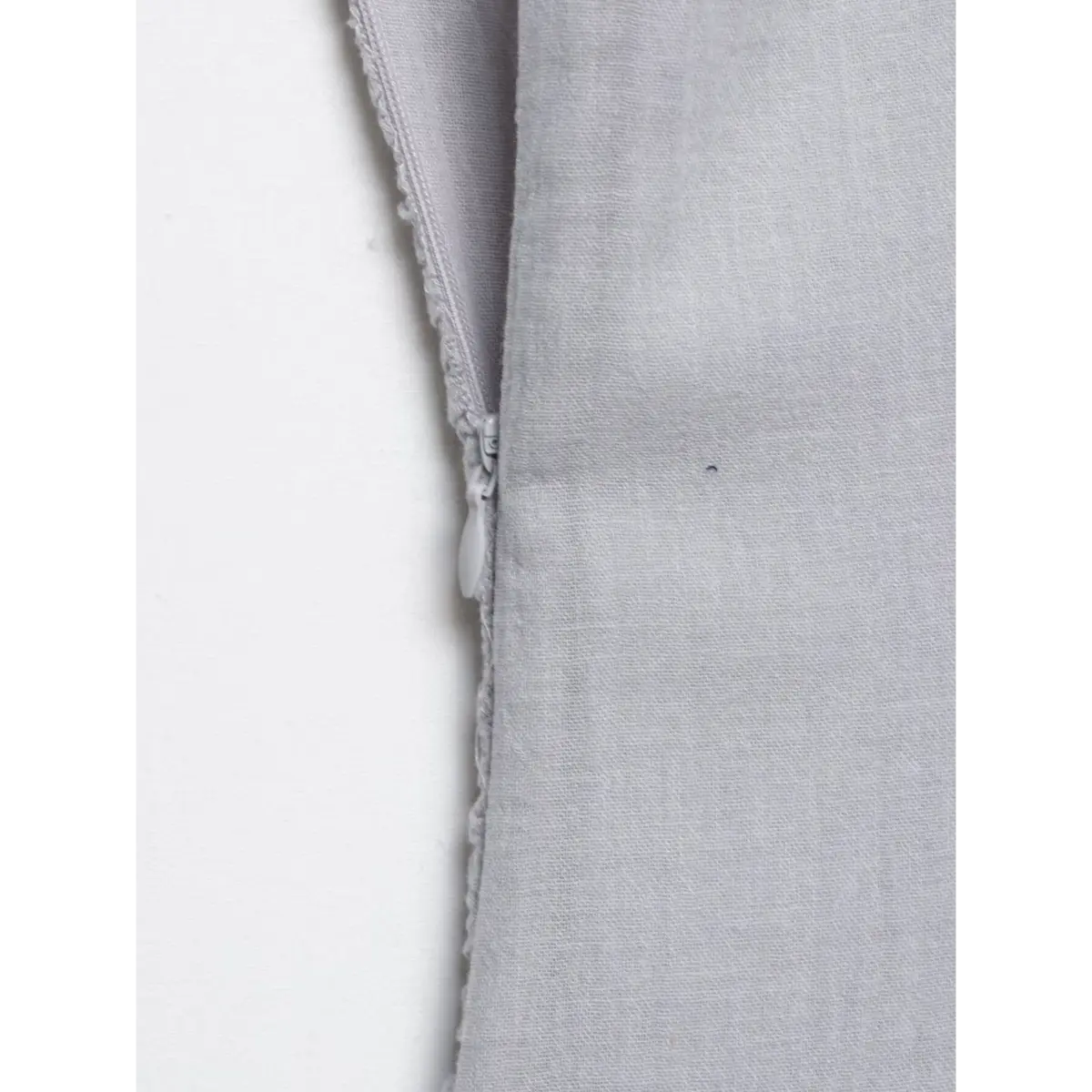 Close-up of the hidden side zipper on a gray cami dress, showing the fabric-covered pull and seamless stitching.