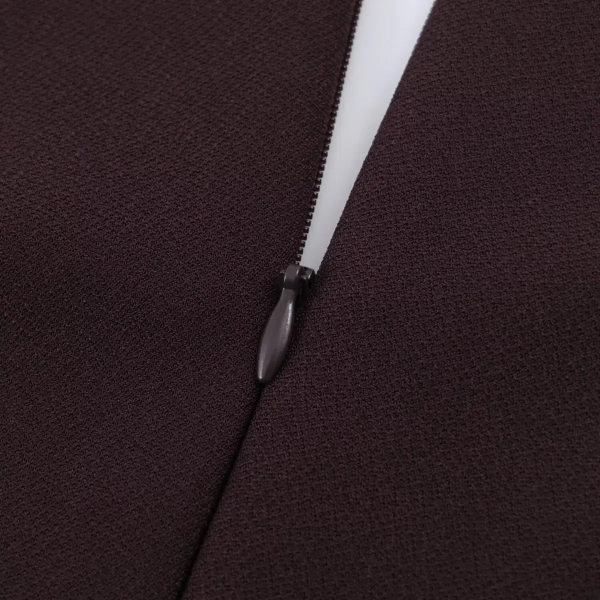 Close-up of the hidden zipper closure on a brown V-neck cap sleeve dress, showing the fabric-covered pull and clean stitching.