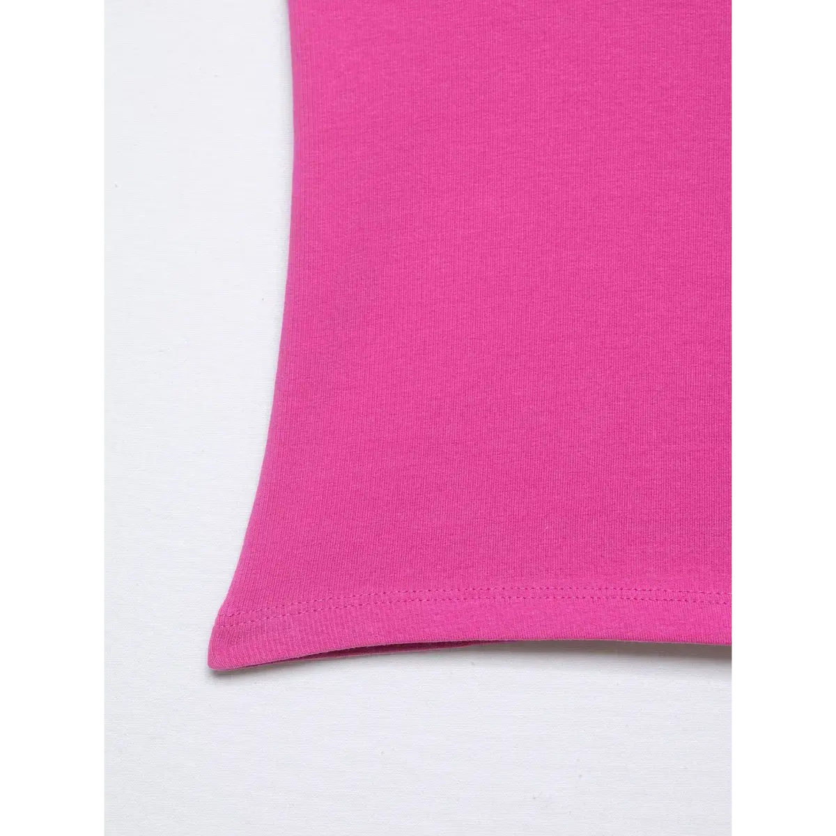 Close-up of the pink halter top's bottom hem, showing the neat stitching and stretchy ribbed fabric texture.