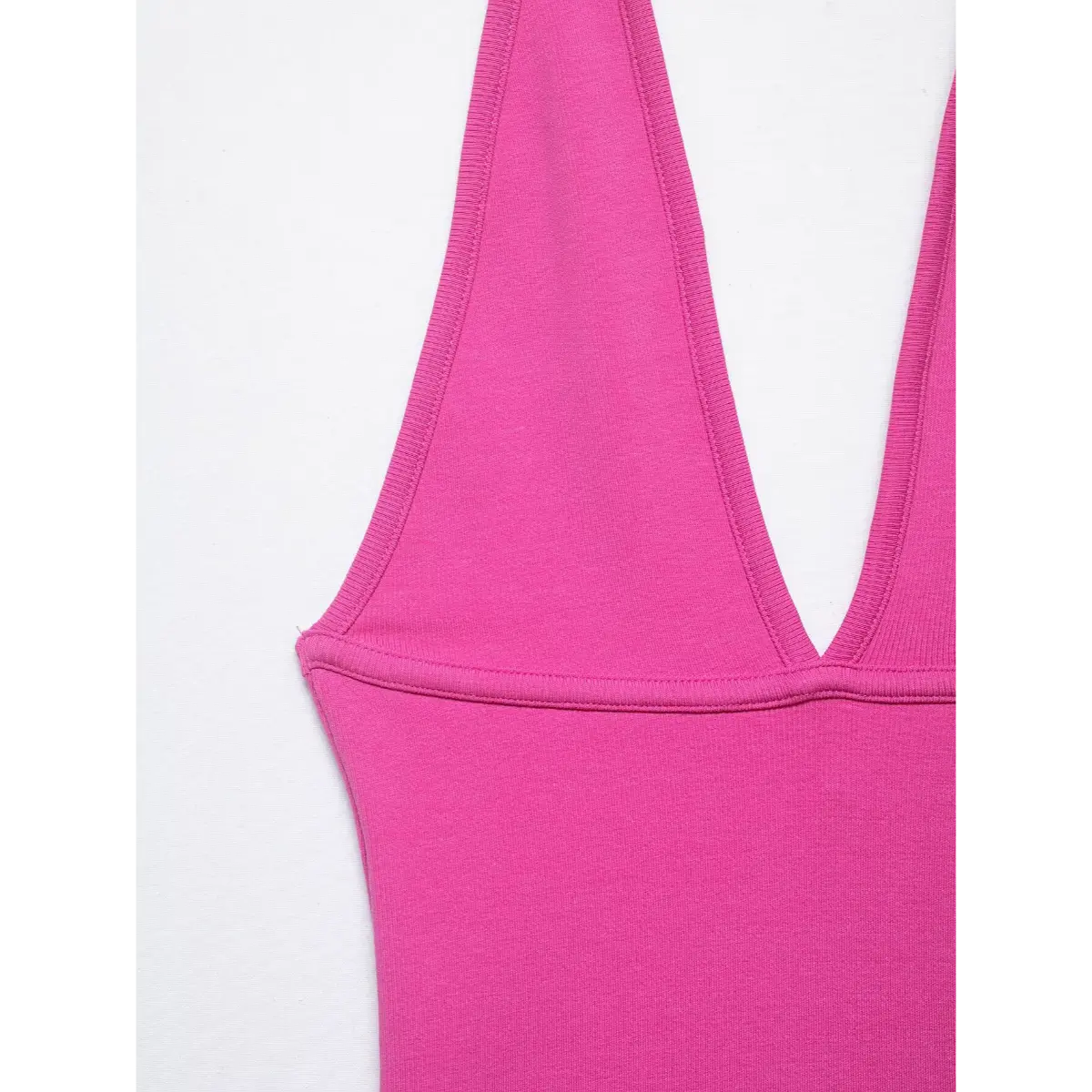 Side-angle close-up of the pink halter top, highlighting the V-neck construction, strap stitching, and smooth fabric finish.