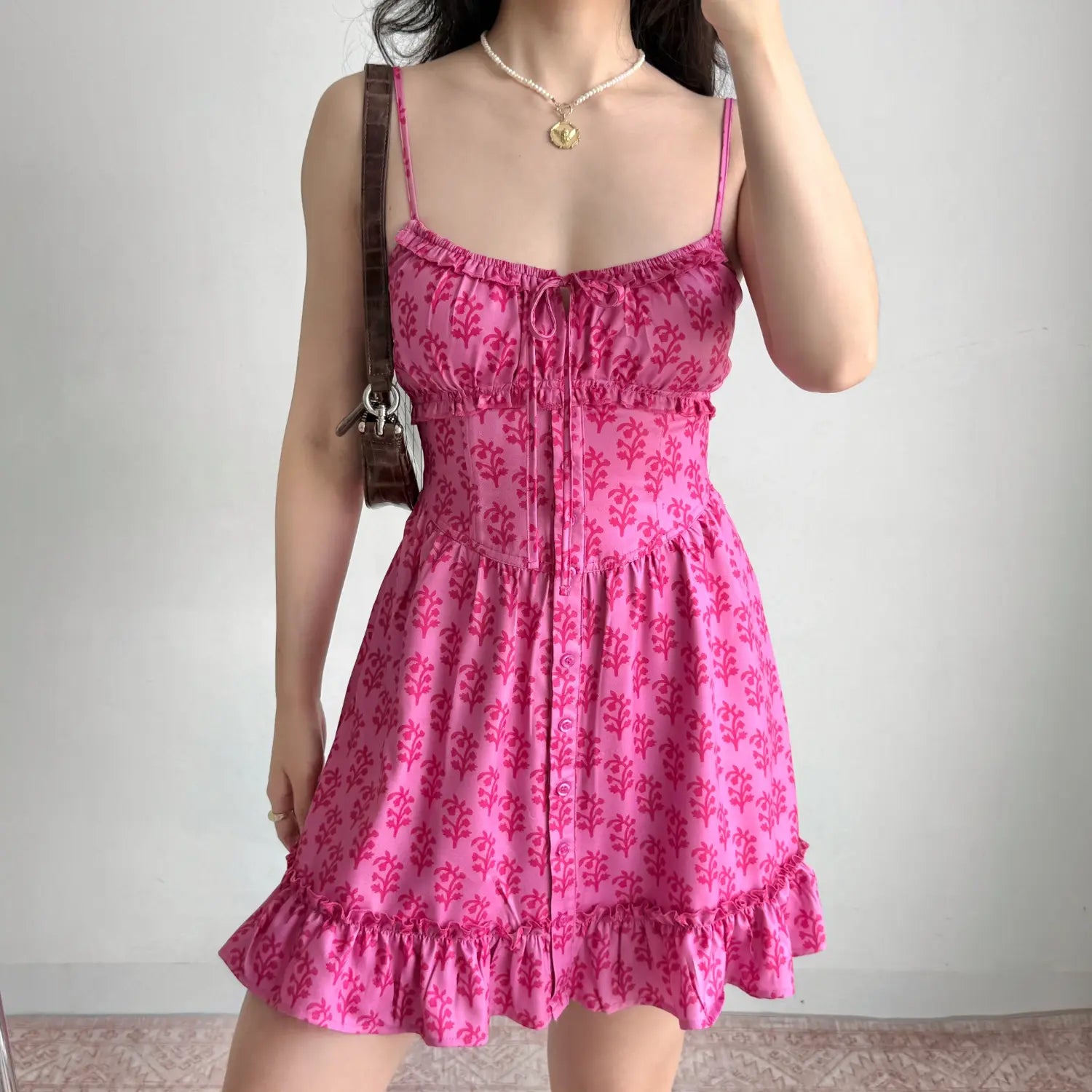 Model full front view hot pink plant print cami mini dress corset waist tie bust detail front button ruffle hem sundress