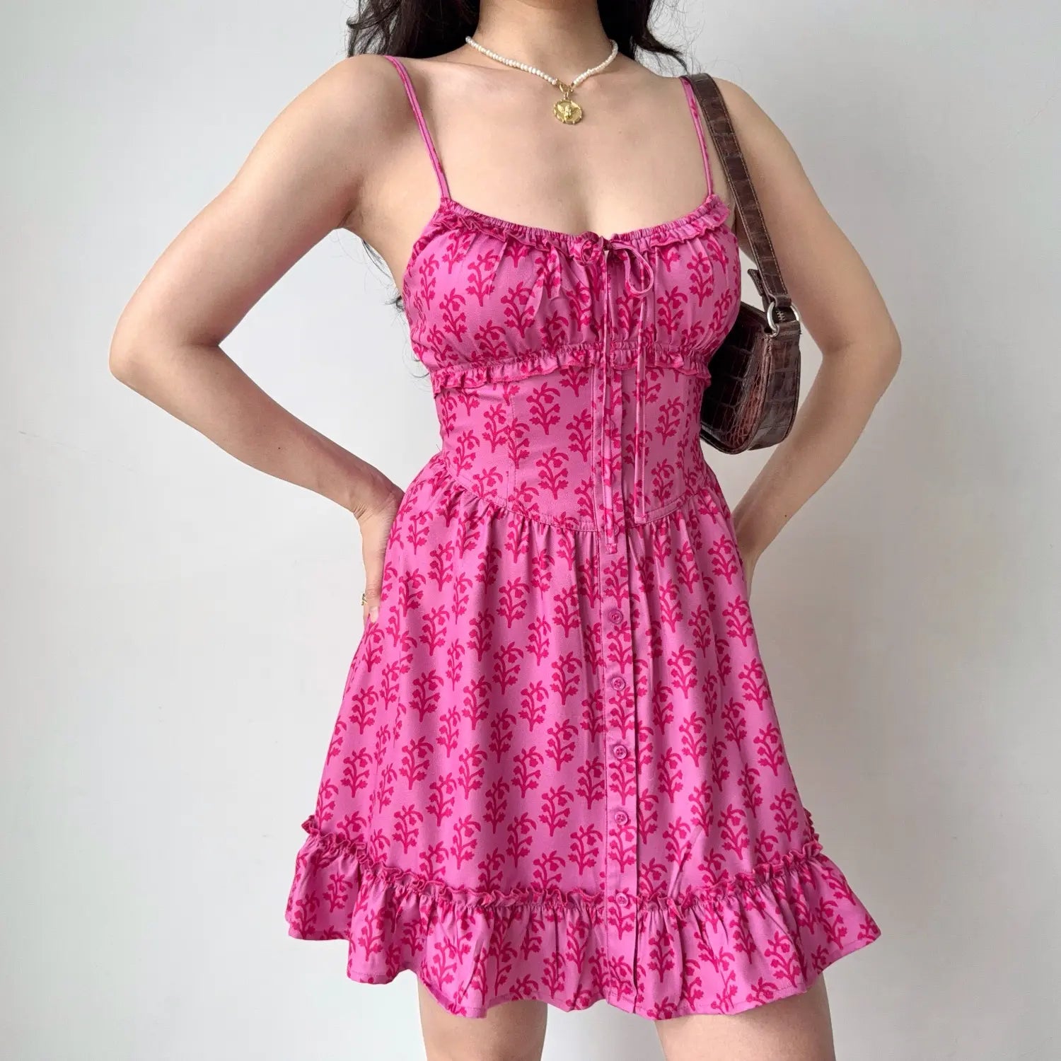 Model hands on hips pose hot pink plant print cami mini dress structured corset waist ruffle trim short sundress