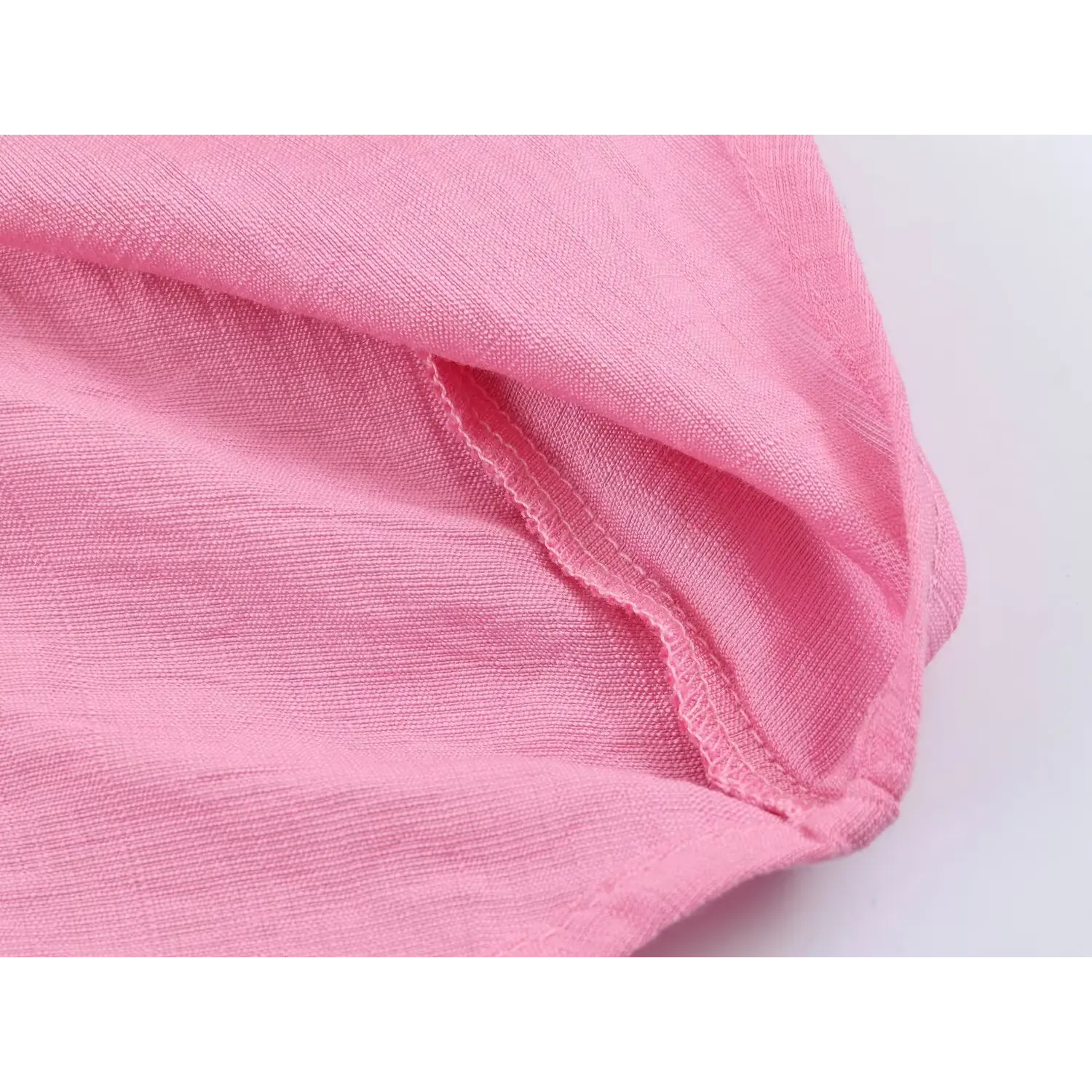 Closeup inner seam stitching, lightweight textured woven hot pink fabric construction detail
