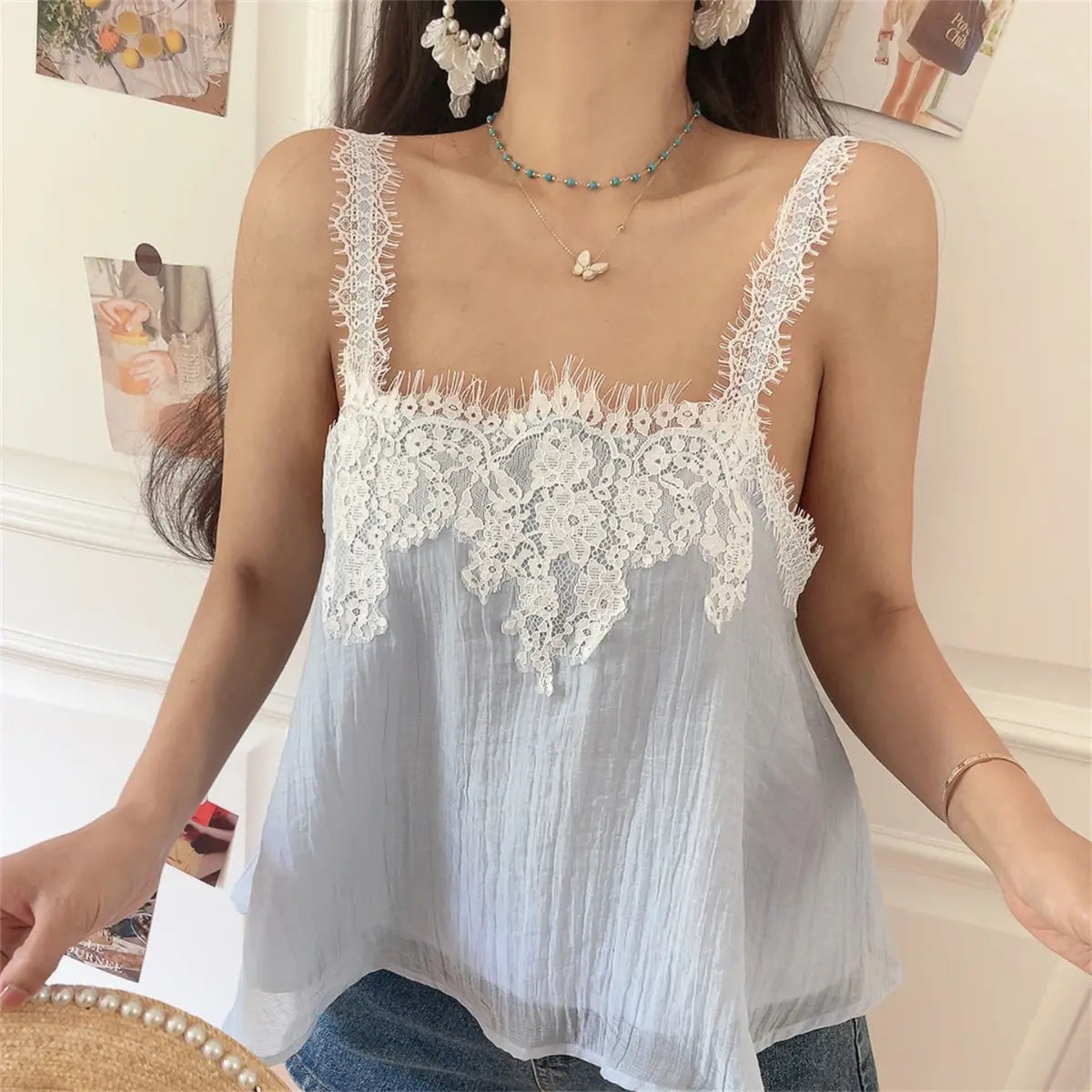 Side view of the light blue lace cami top, emphasizing the lace trim and flowy fabric.
