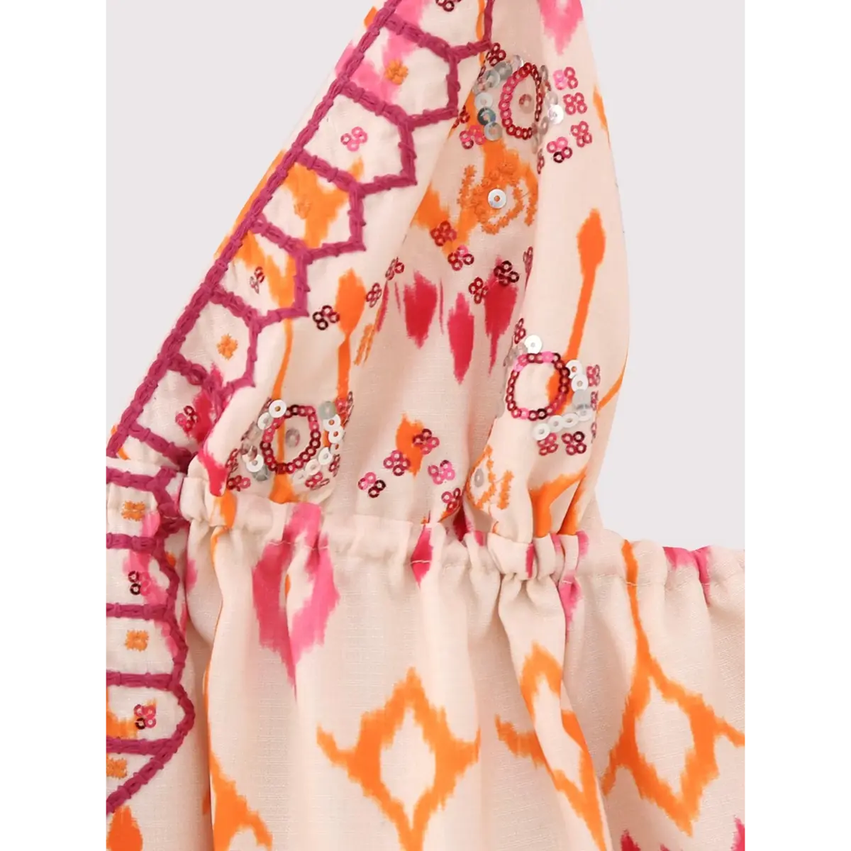 Close-up of the bust area on the ikat print cami top, showing the gathered seam, embroidery, and sequin details