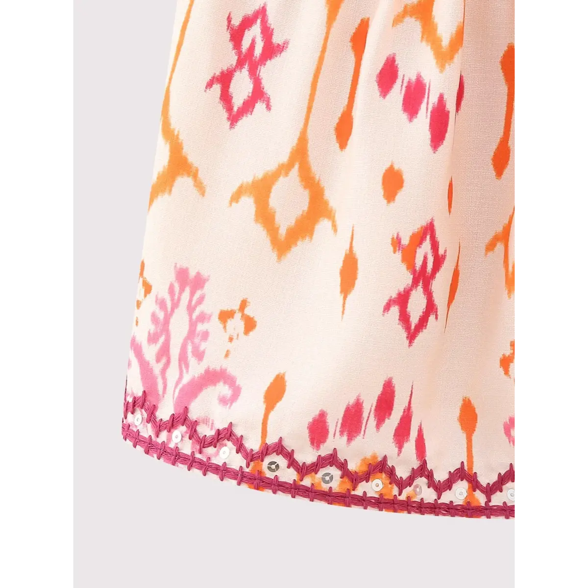 Close-up of the V-neckline on the ikat print cami top, showing the gathered bust and layered fabric