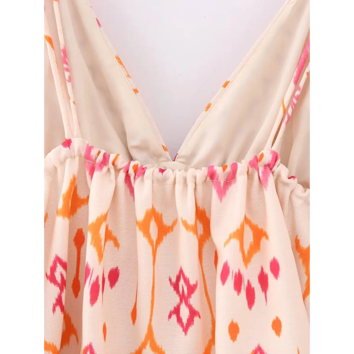 Close-up of the V-neckline on the ikat print cami top, showing the gathered bust and layered fabric