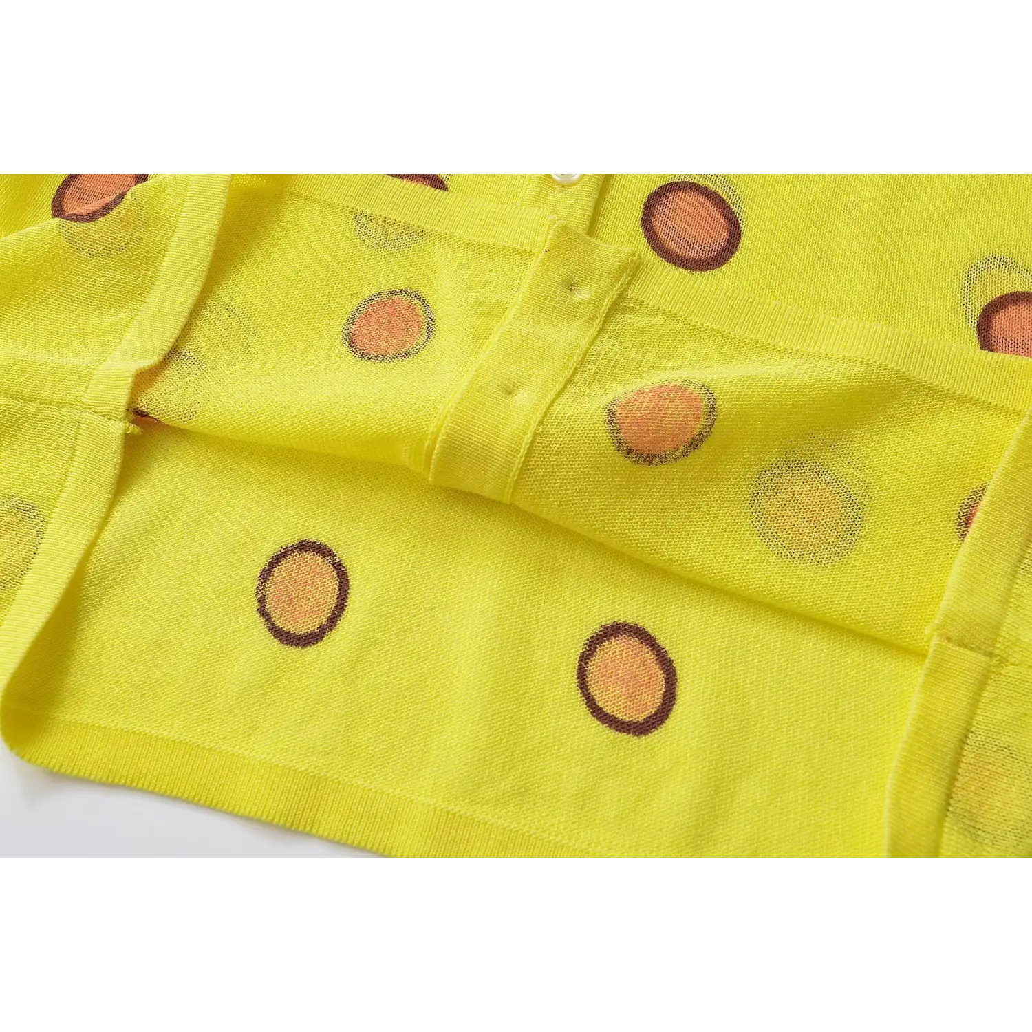 Fabric fold close-up, semi-sheer thin knit texture, reverse side polka dot printing detail