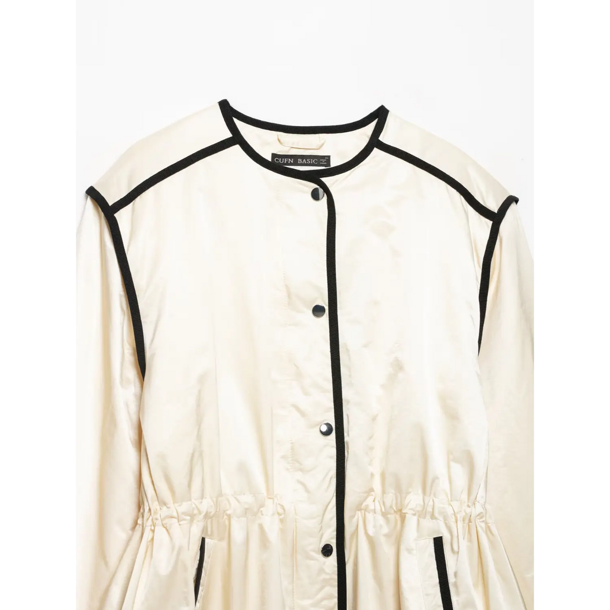 Close-up of crew neckline, brand label and snap buttons