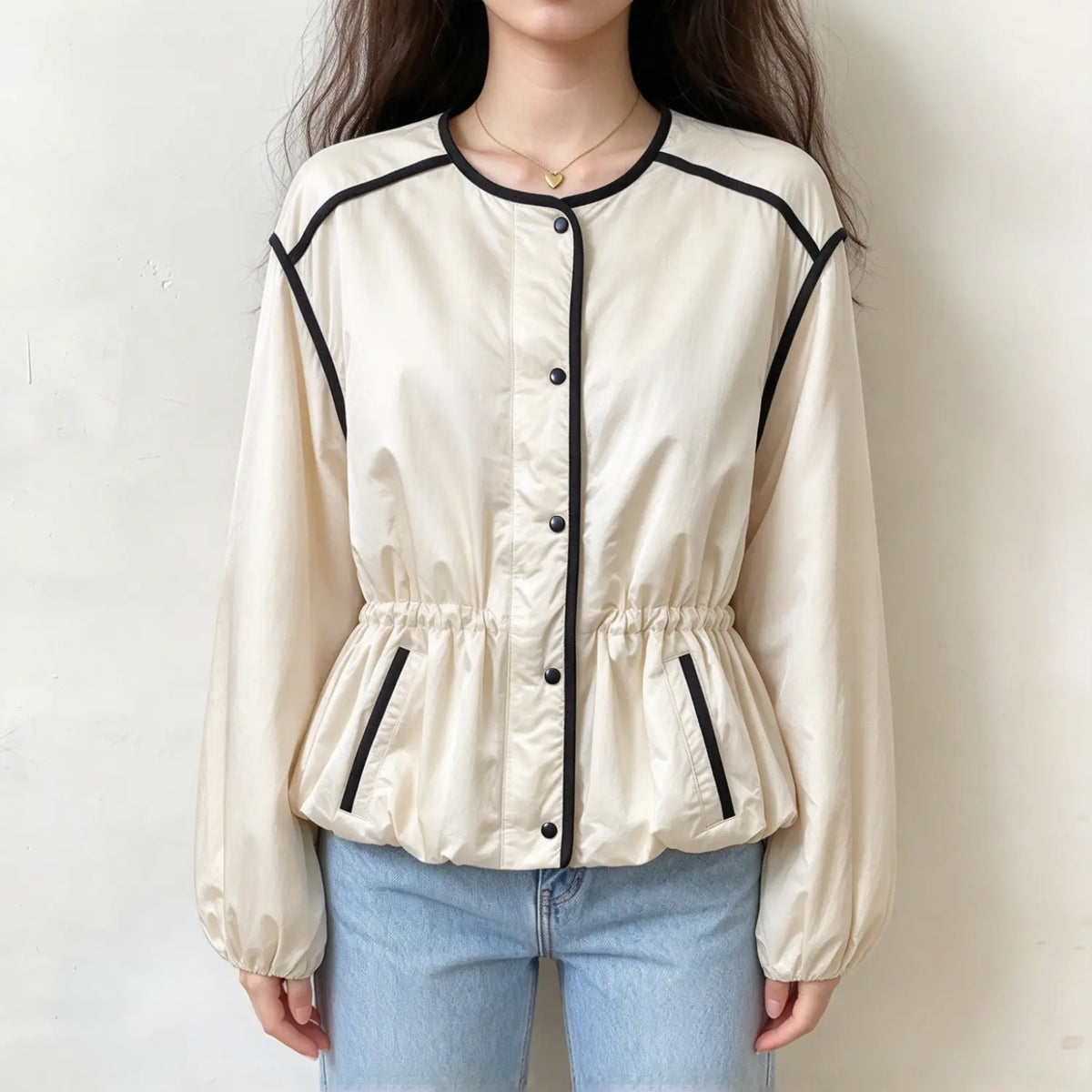 Model wearing ivory black trim crew neck gathered waist puff sleeve jacket