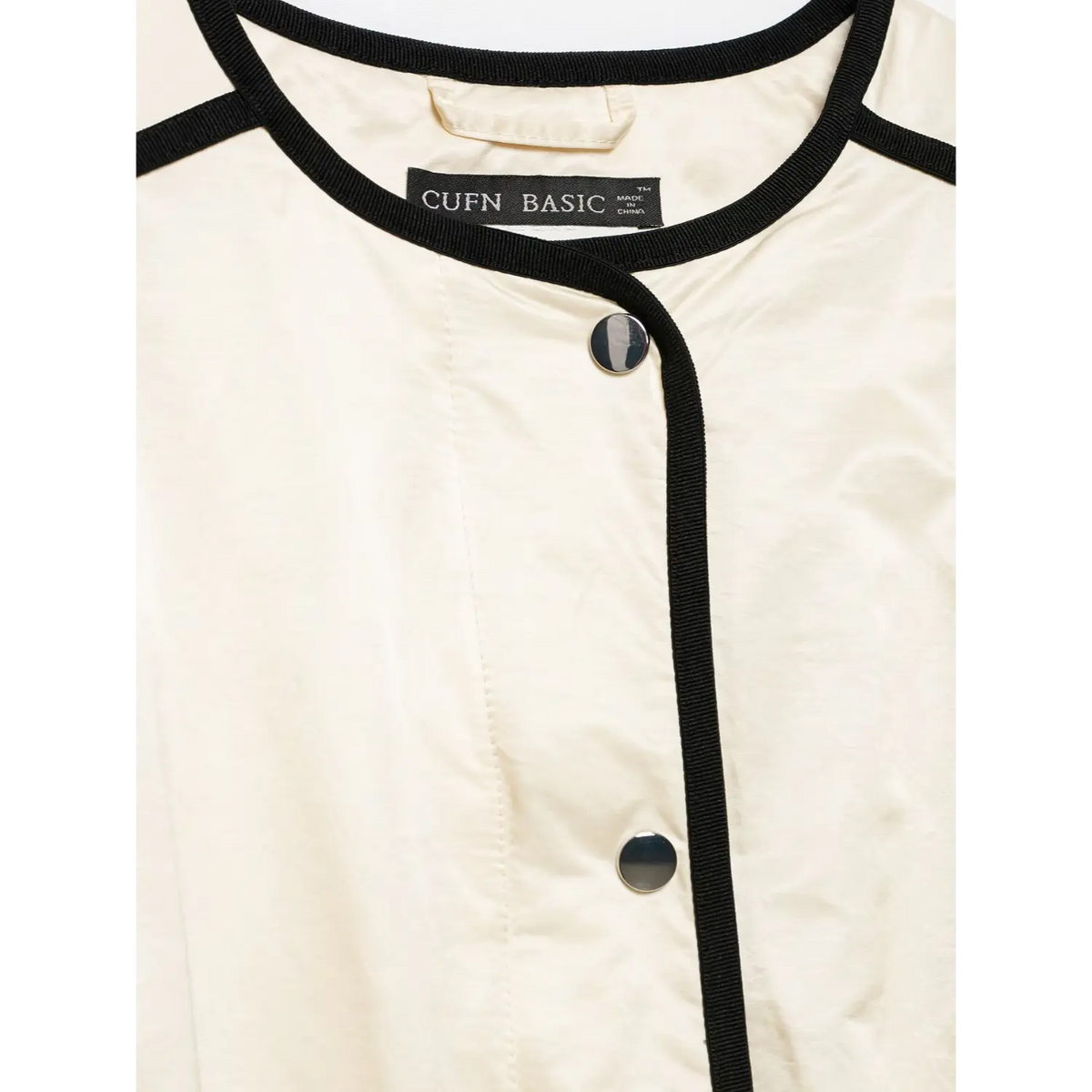 Close-up of neckline label and snap button placket