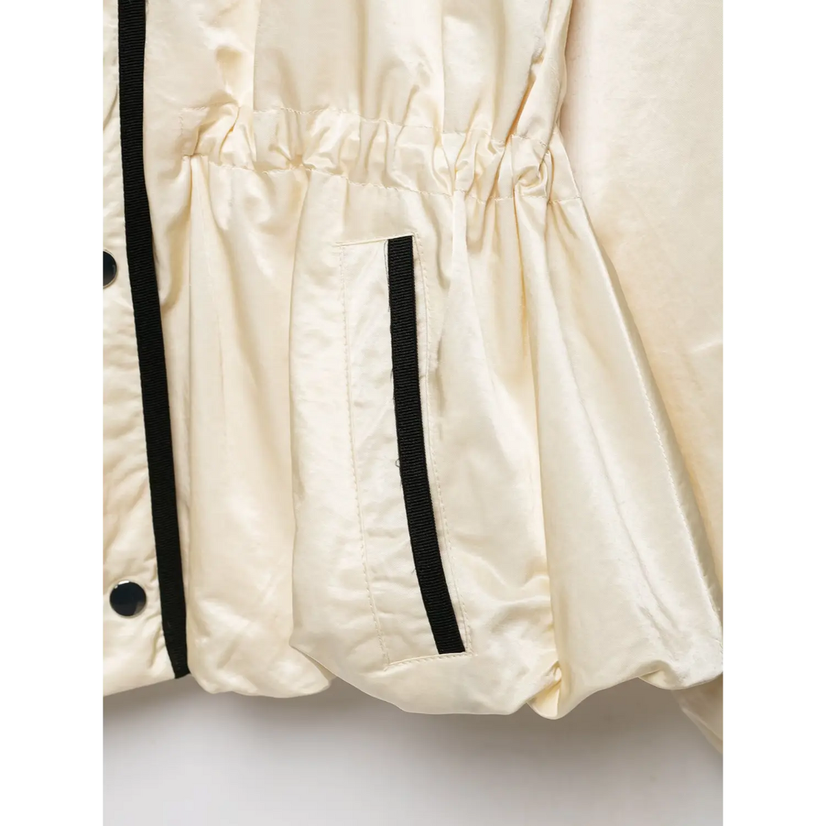 Close-up of pocket with black trim and gathered waist
