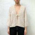 Model wearing ivory crochet lace cropped jacket with black jeans