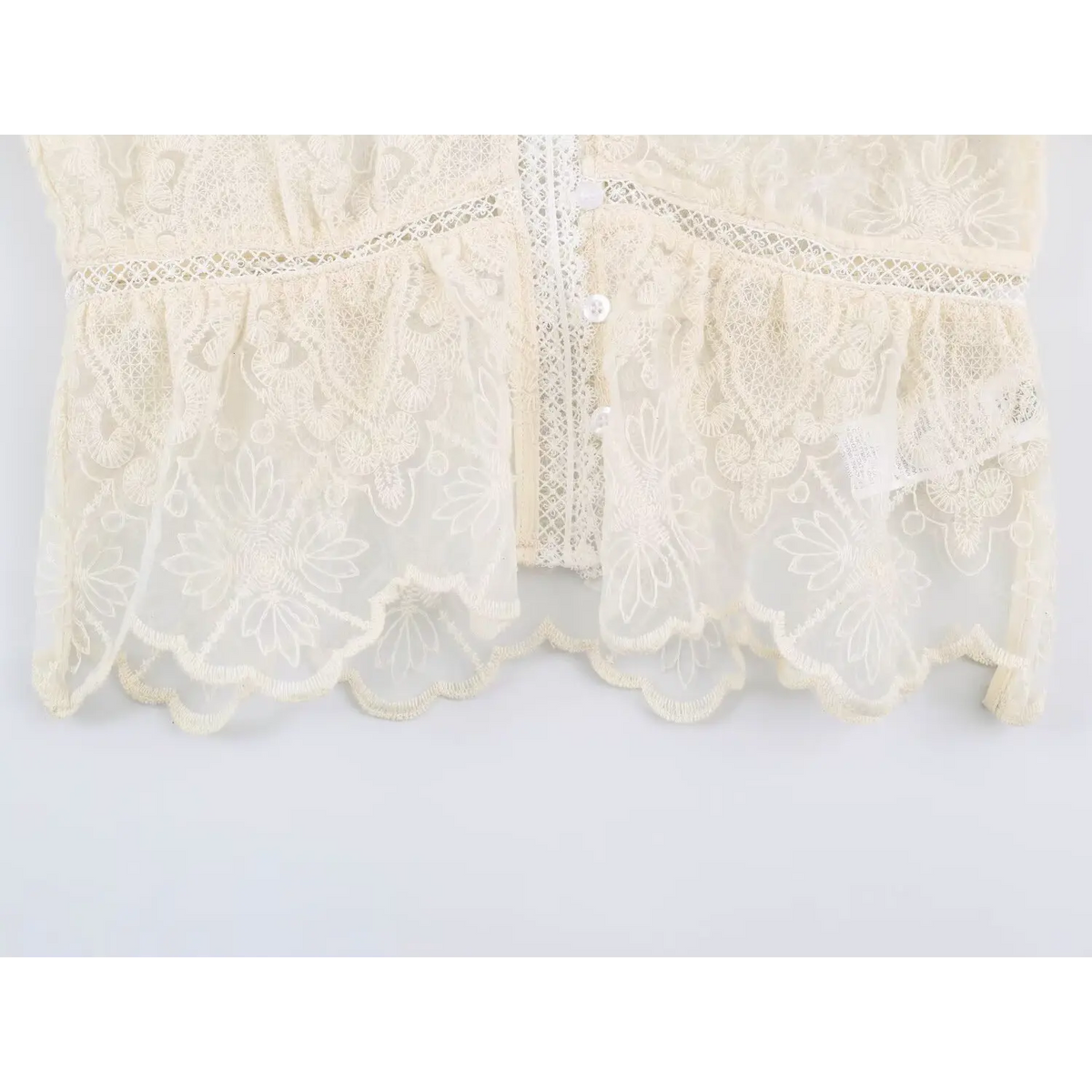 Close-up of gathered peplum hem and scalloped edge