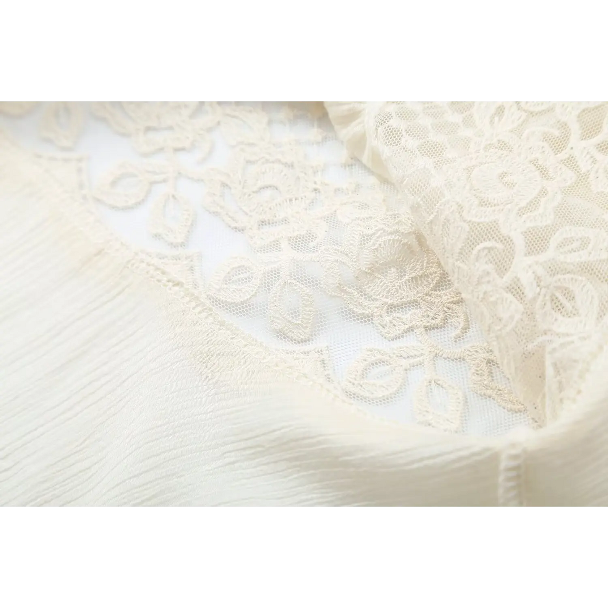 Close-up of floral lace and chiffon fabric join