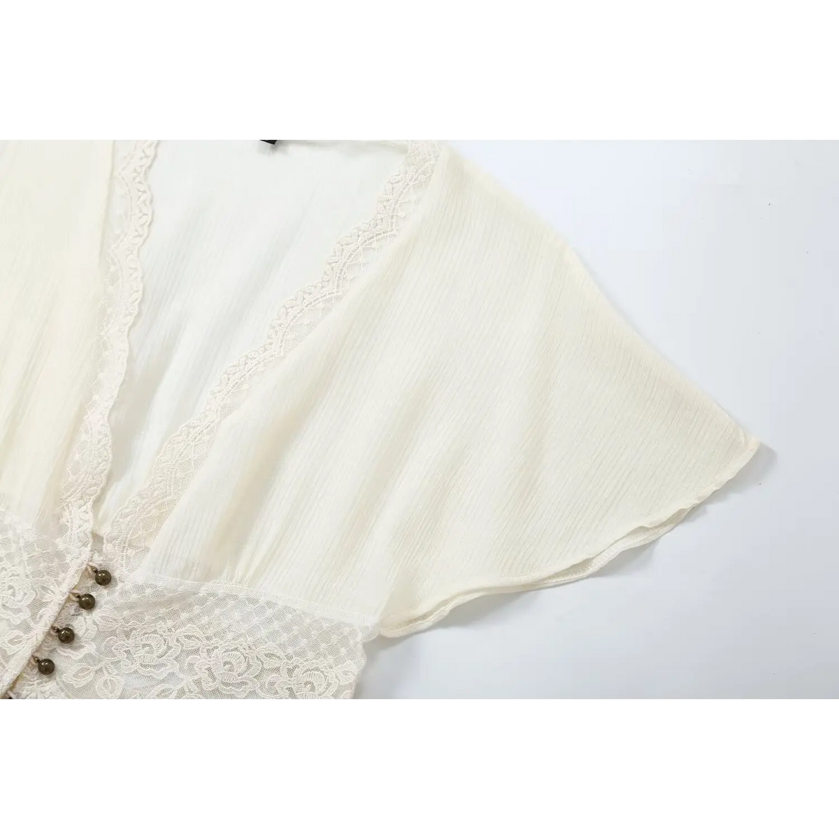 Close-up of V neck lace trim and flutter sleeve