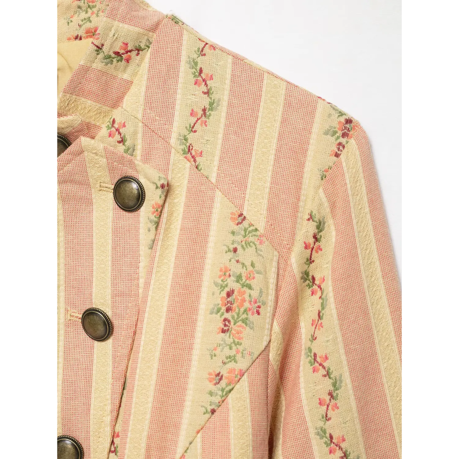Extreme closeup shoulder, stand collar and vintage metal button on pink floral stripe woven outerwear